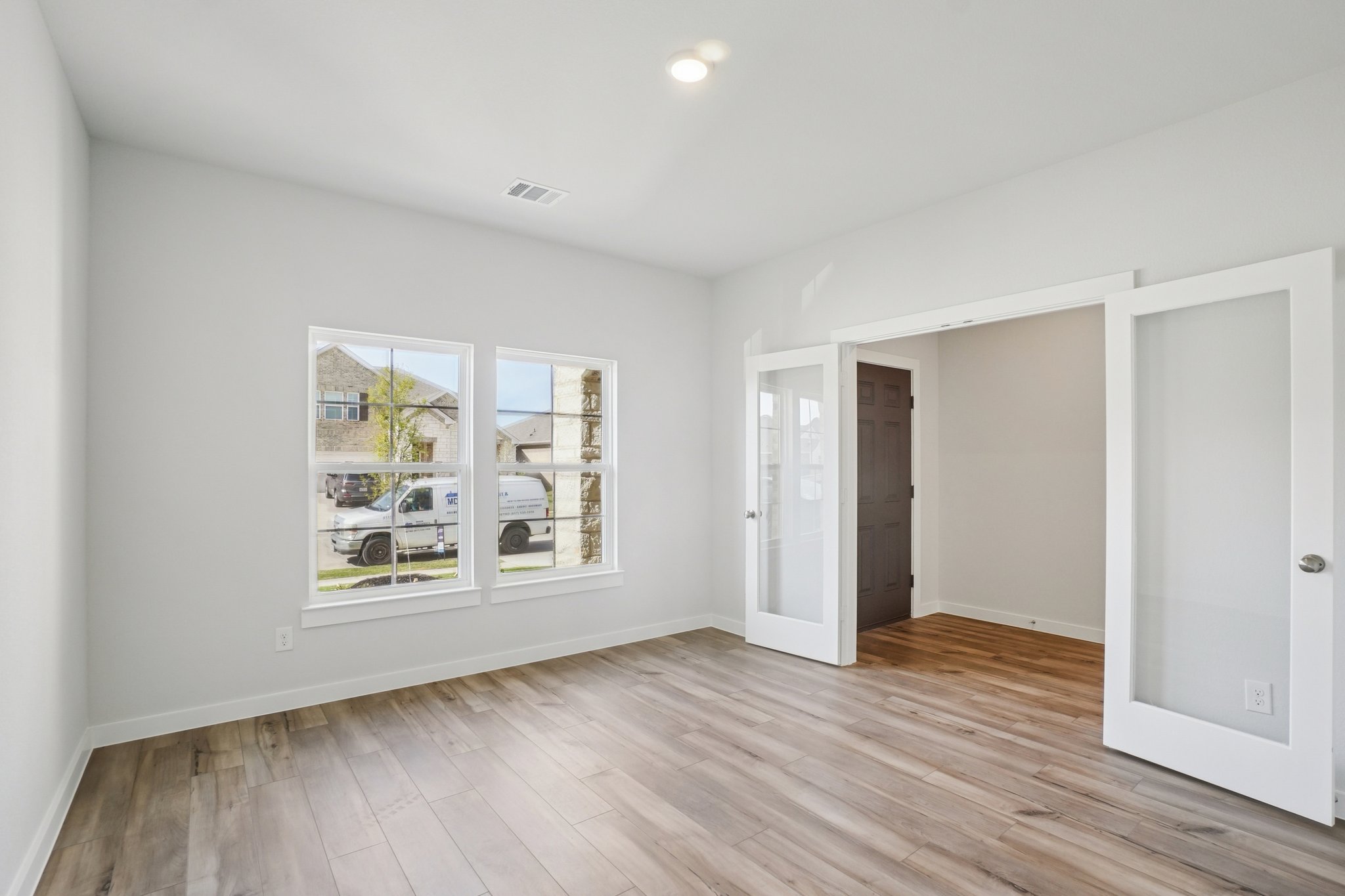 A room with a wood floor and white walls.