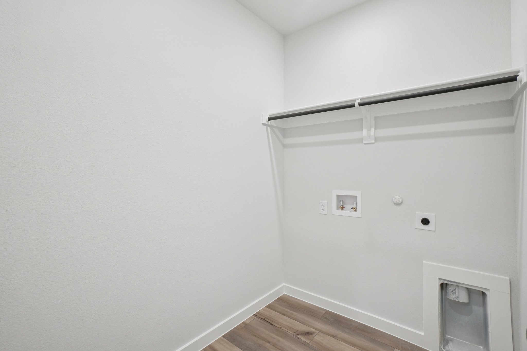 A white room with a wood floor.