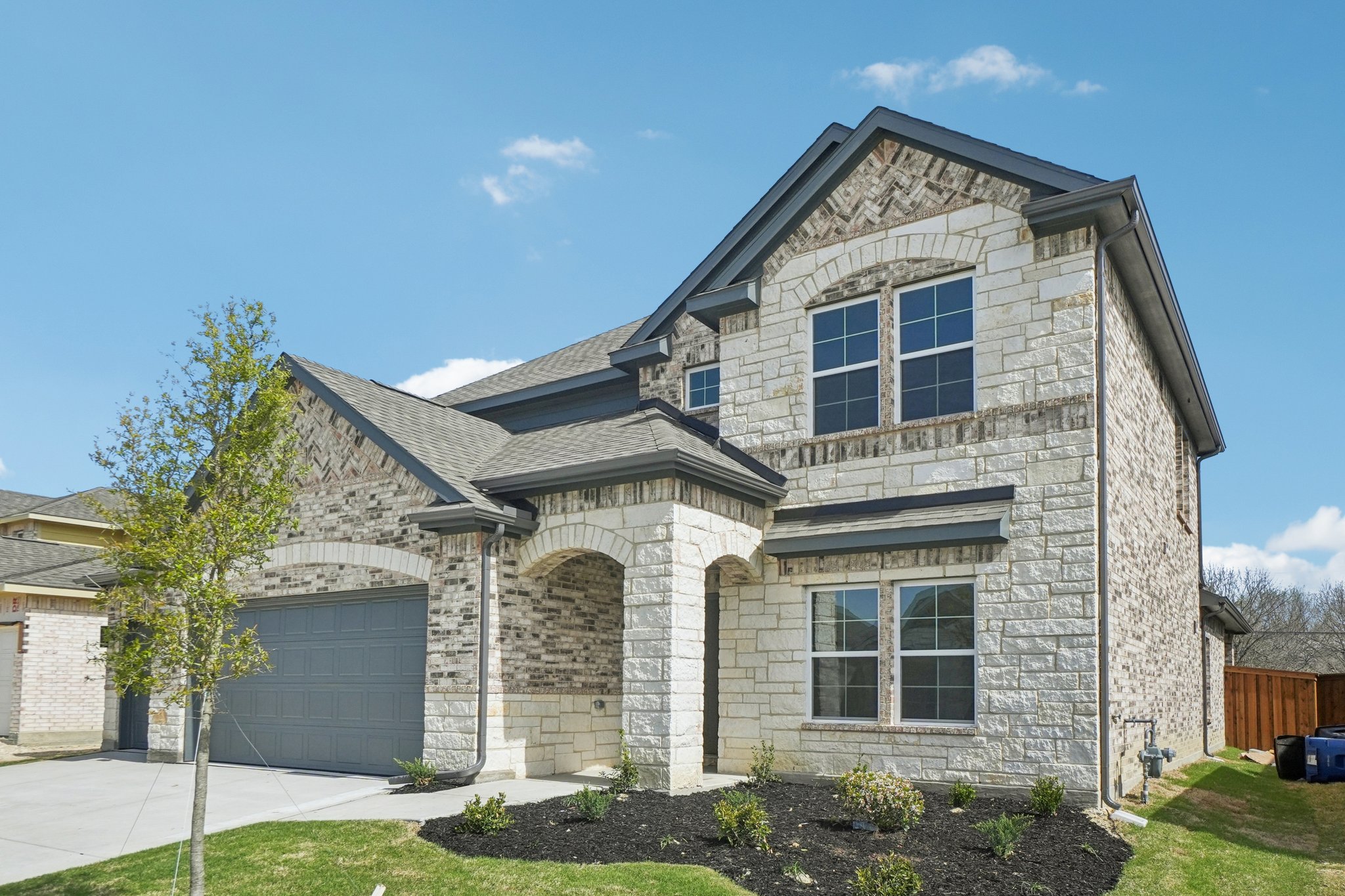 A stone house with a garage.