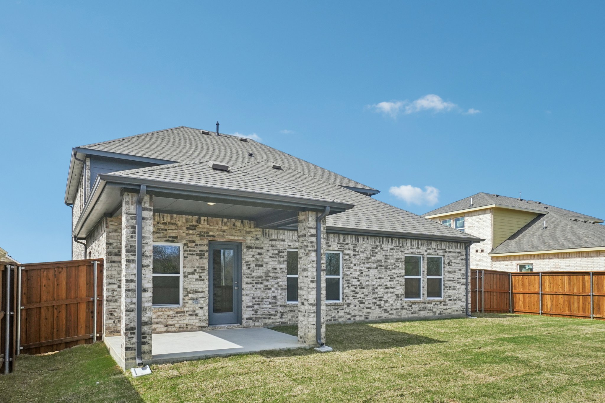 A stone house with a fence.
