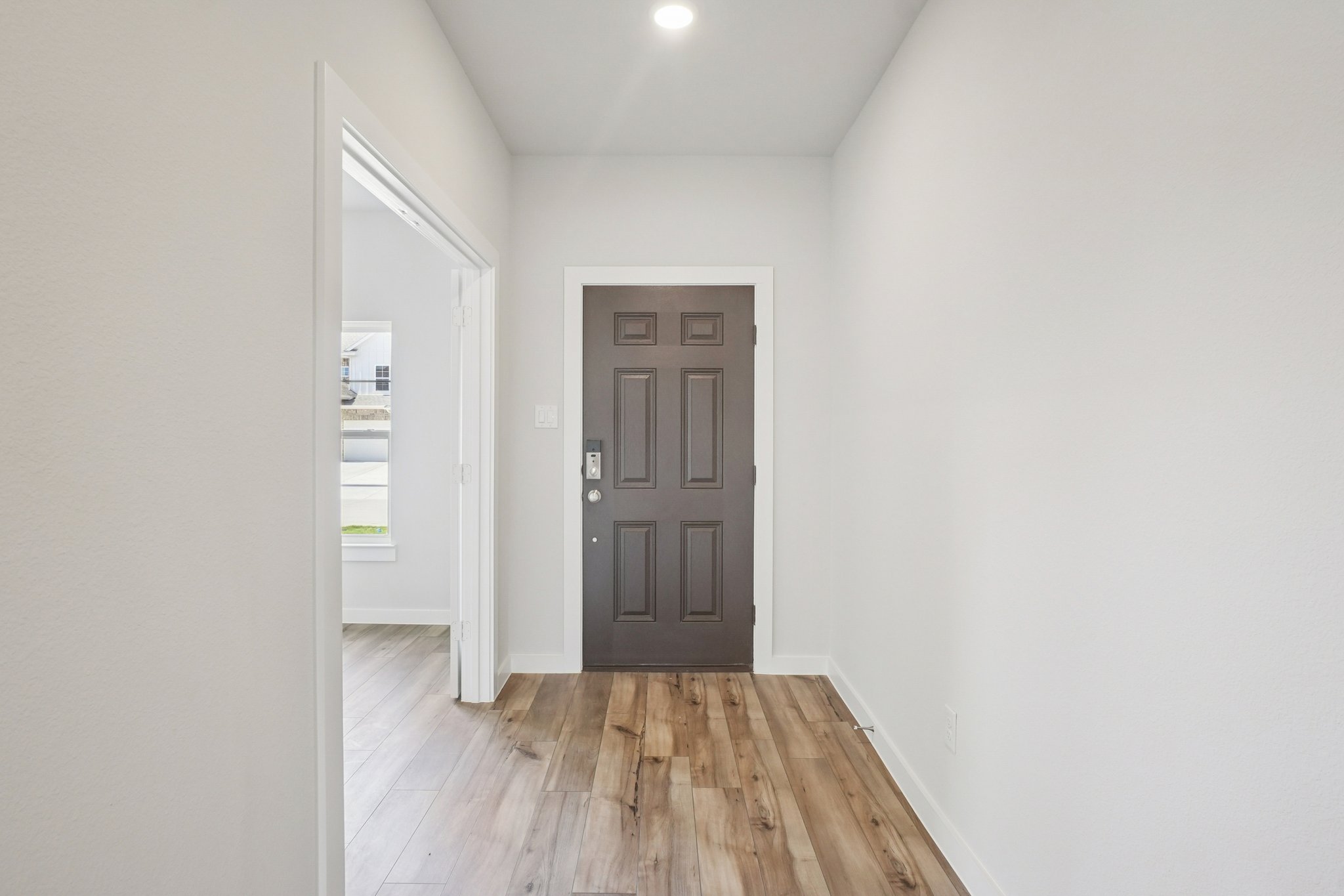 A room with a wood floor and a door with a window.