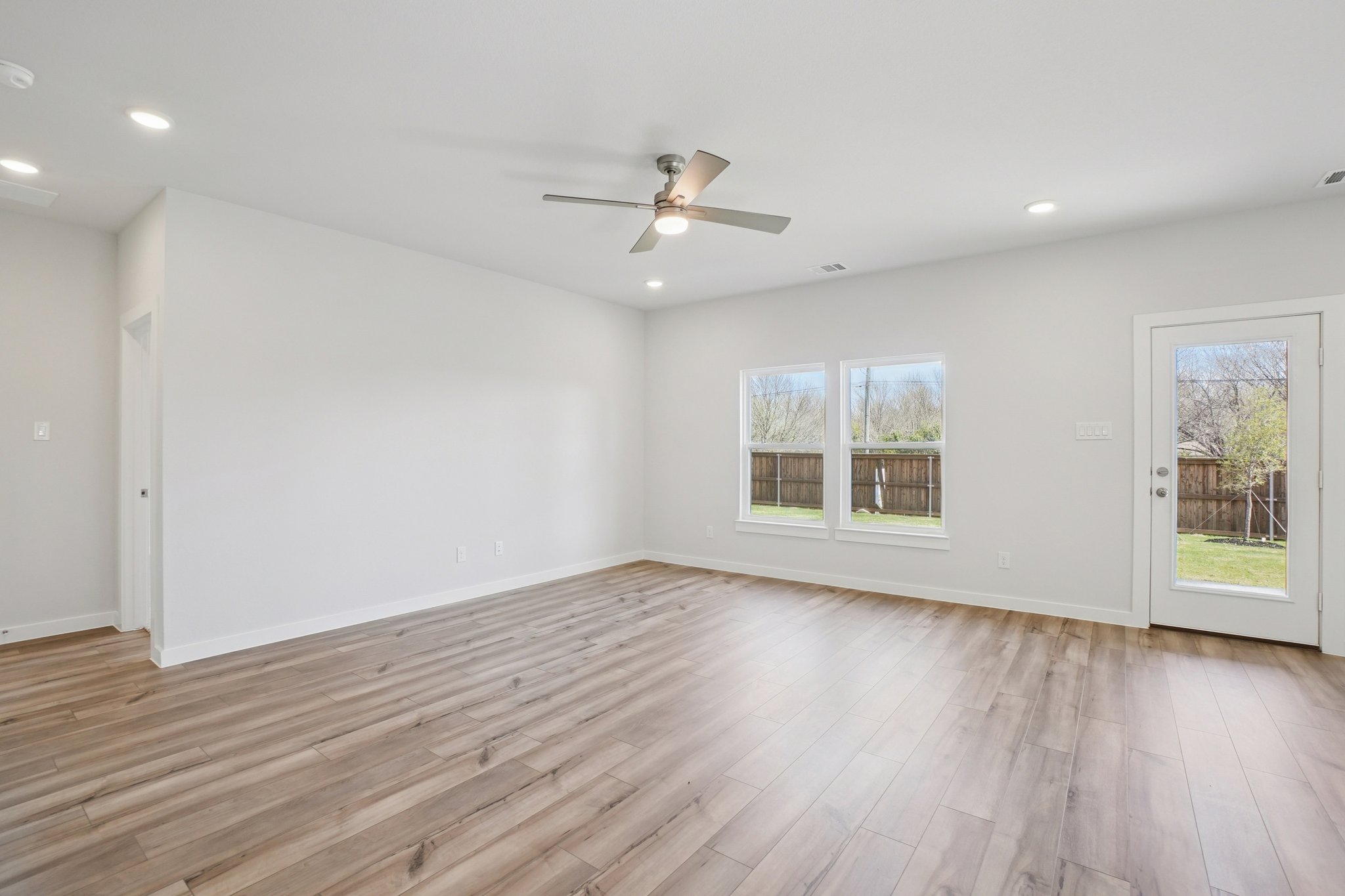 A room with a wood floor and a ceiling fan.