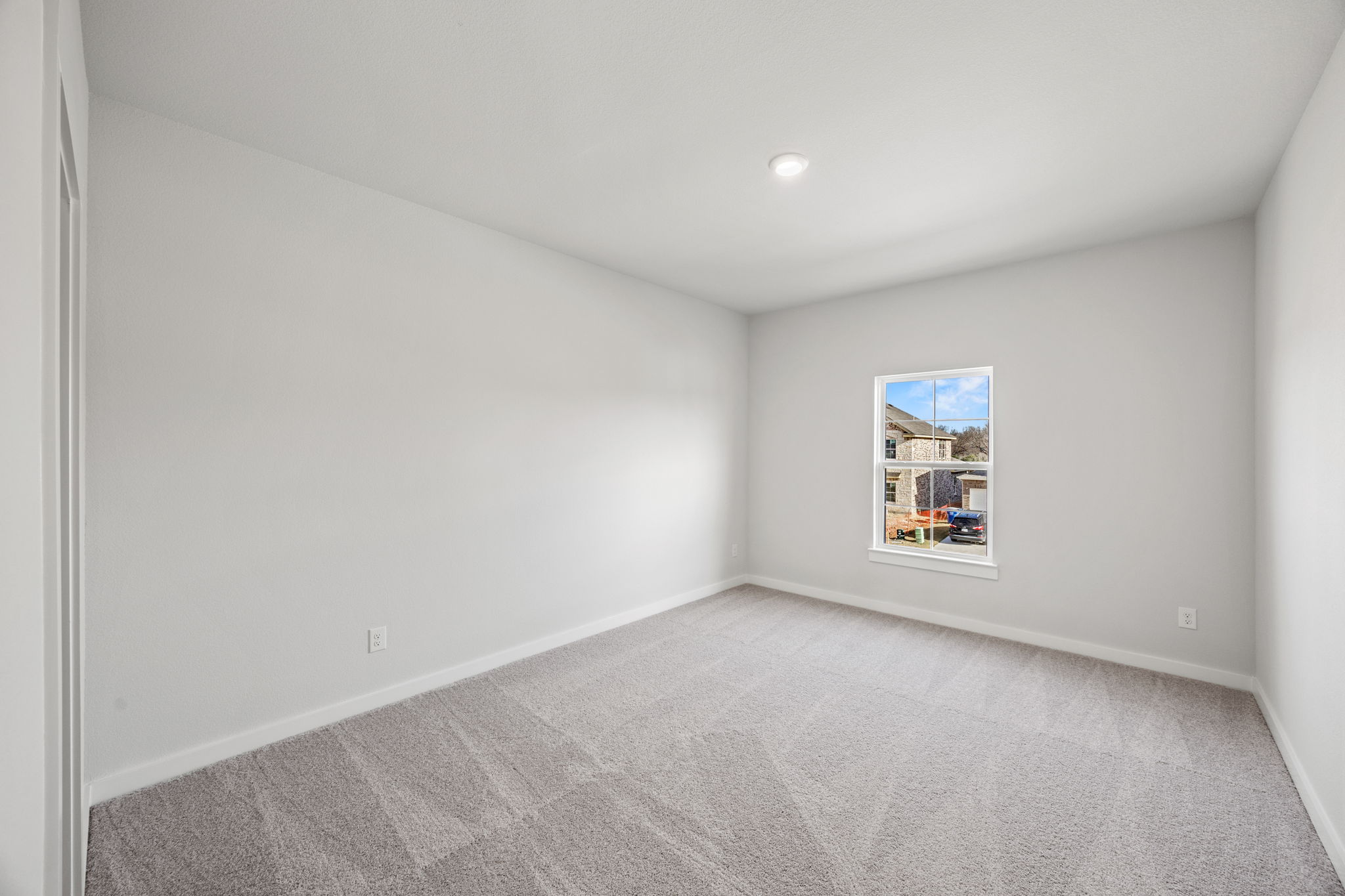 A room with a carpet and a window.