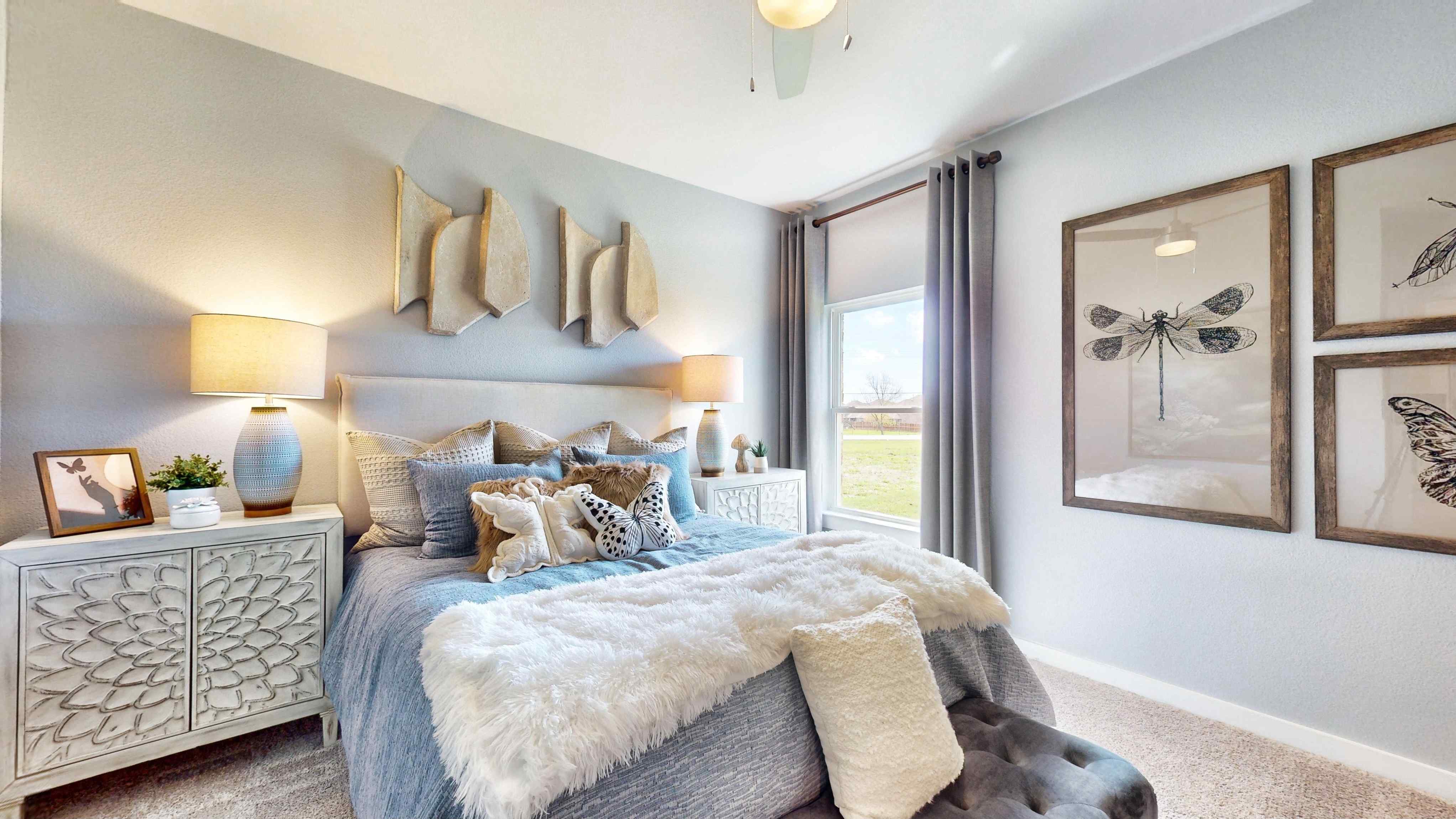 A bedroom with a bed and lamps.