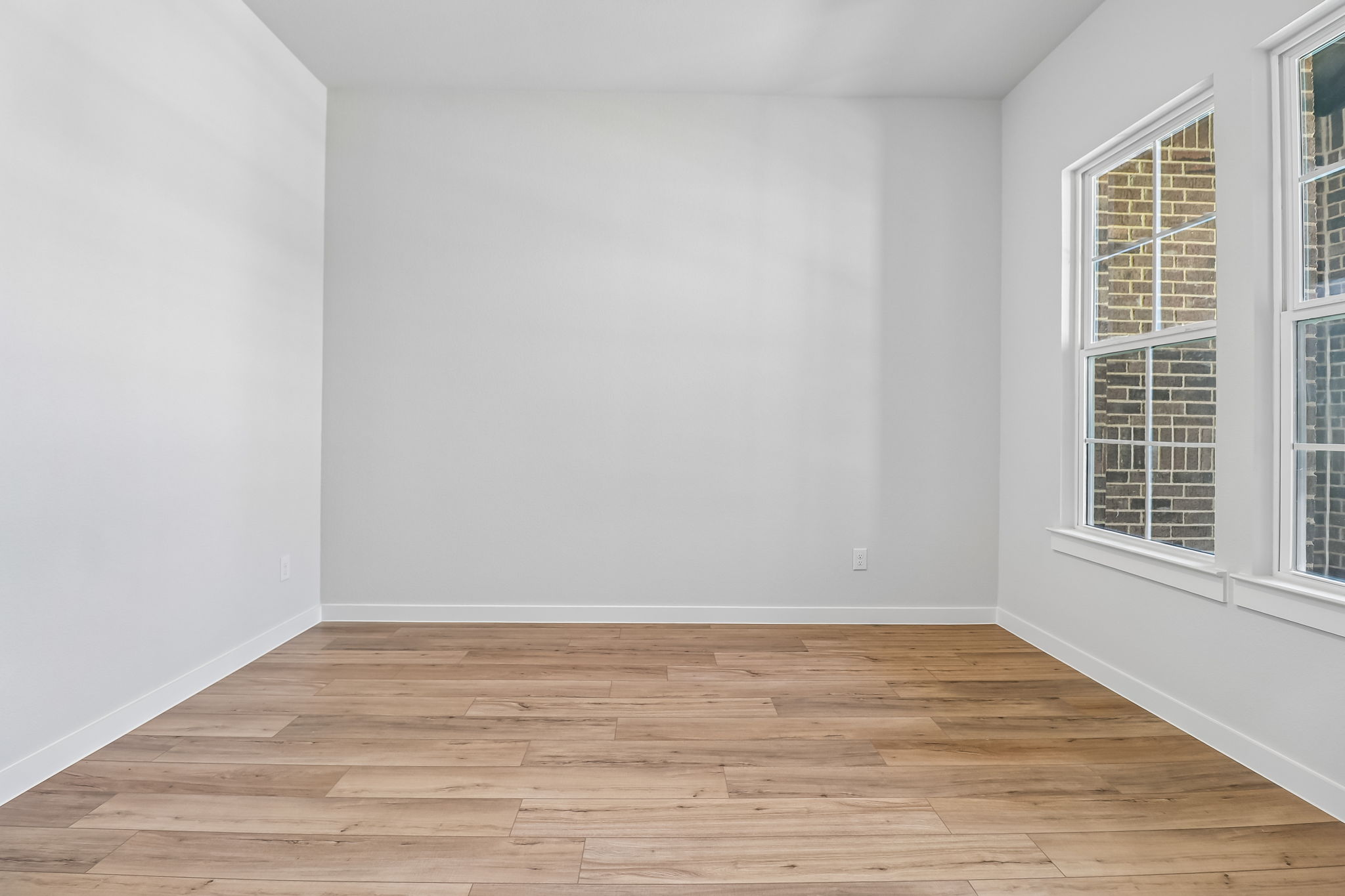 A room with a wood floor and white walls.