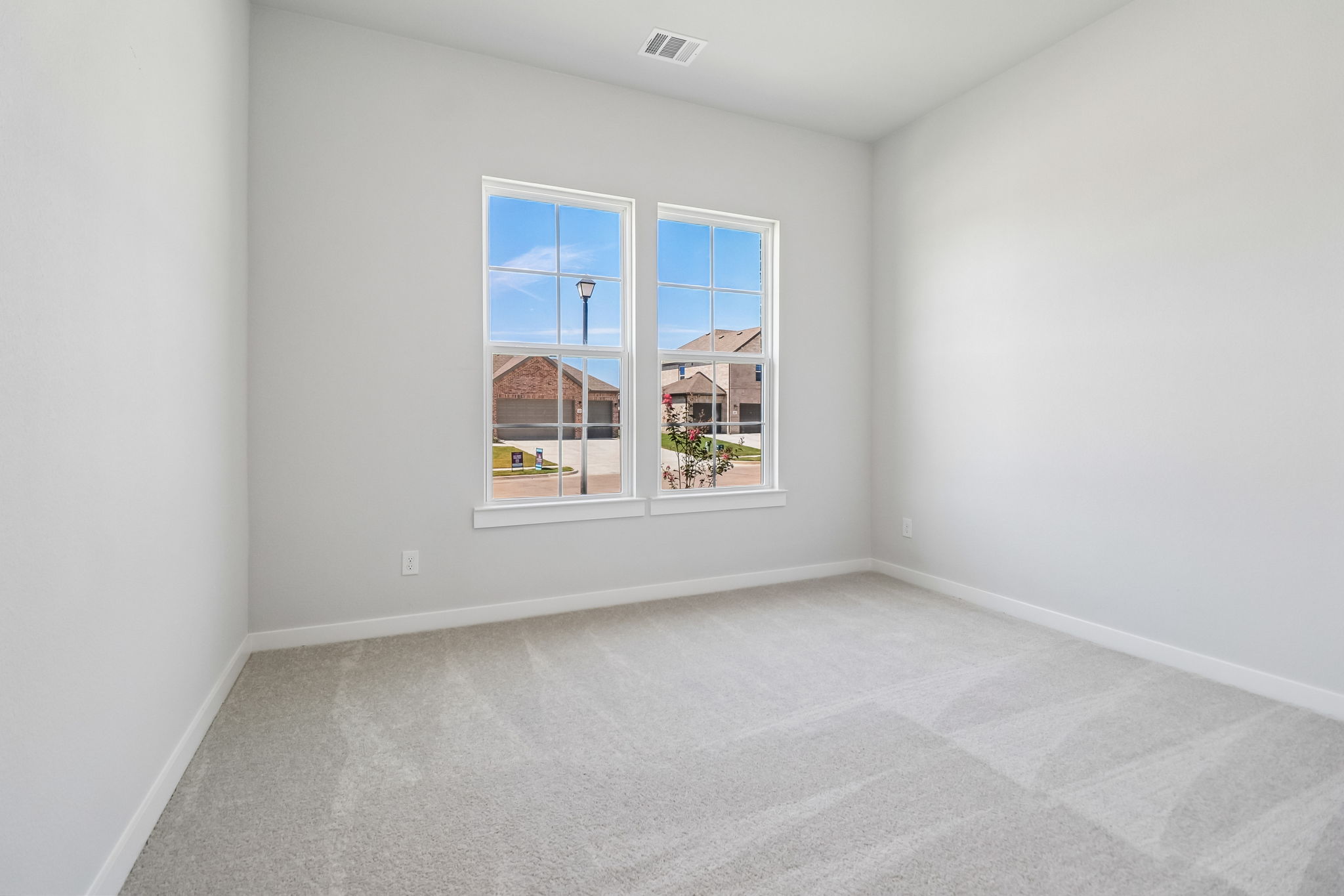 A room with a window and a rug.