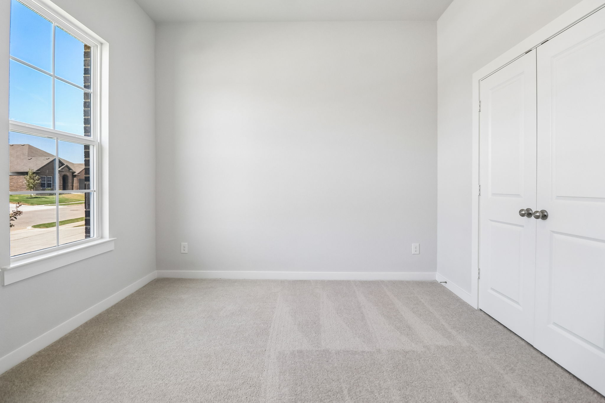 A room with white walls and a window.