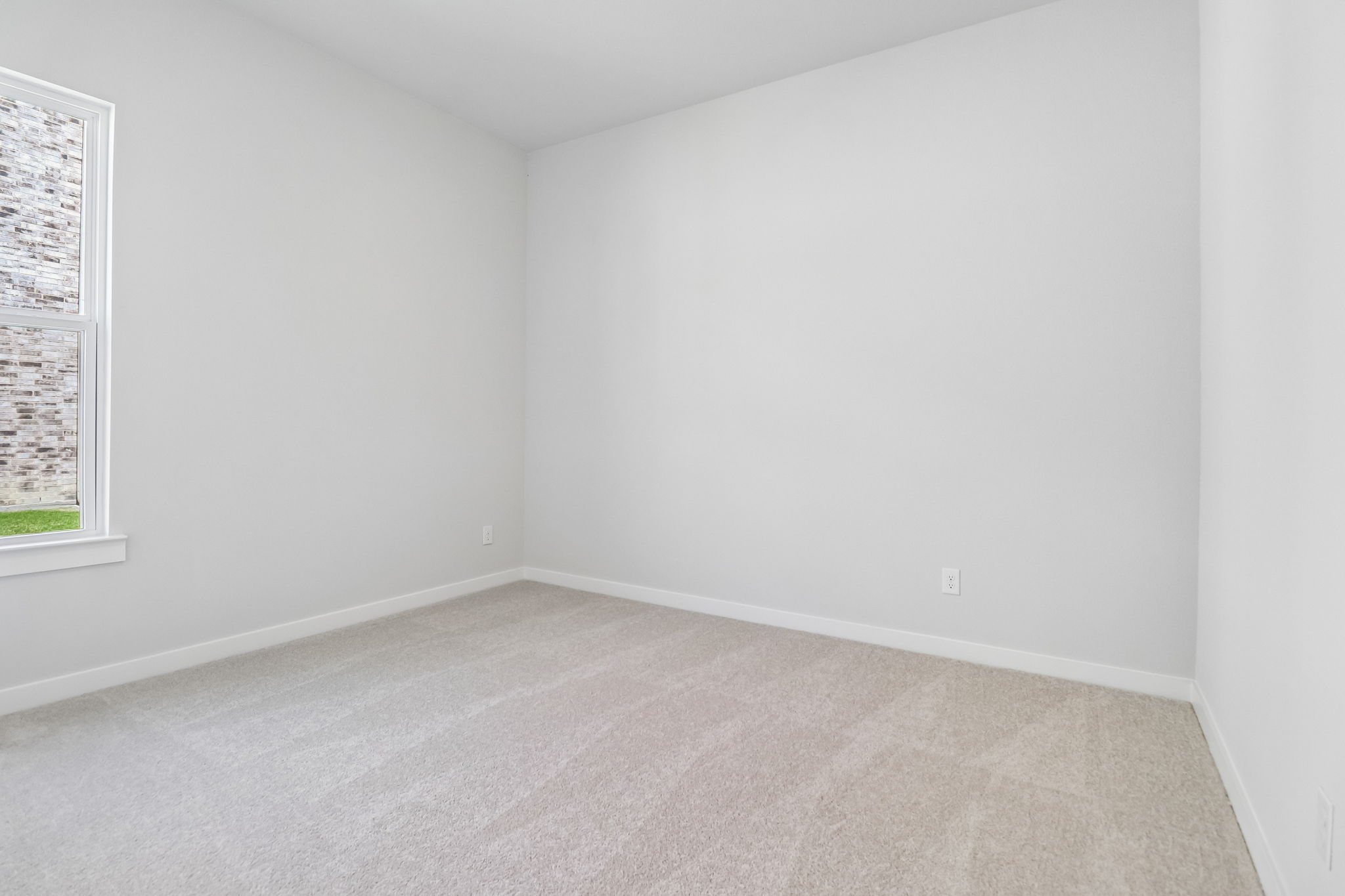 A room with a carpet and a window.