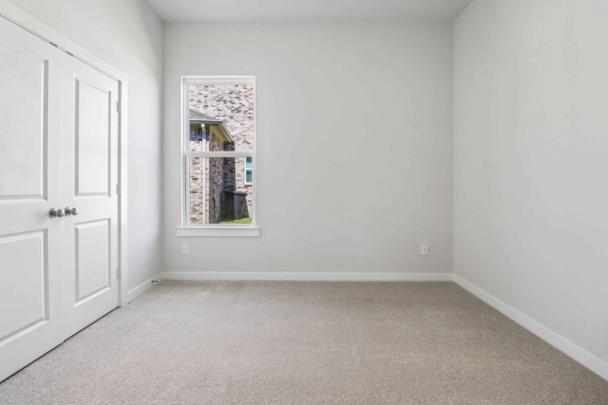 A room with white walls and a window.
