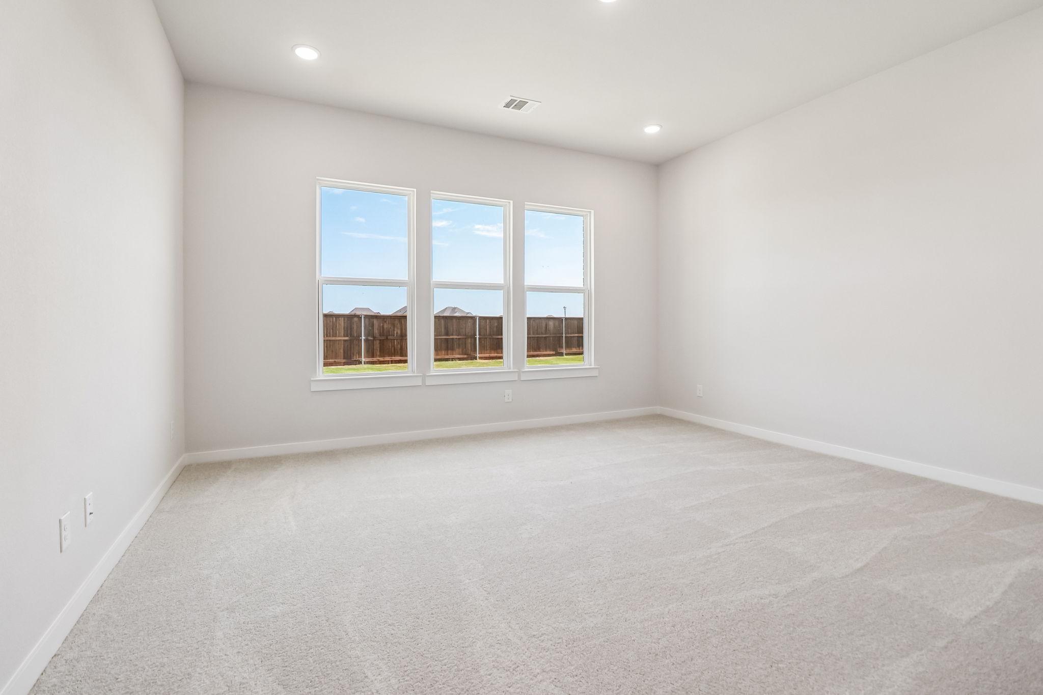 A room with a window and a white wall.