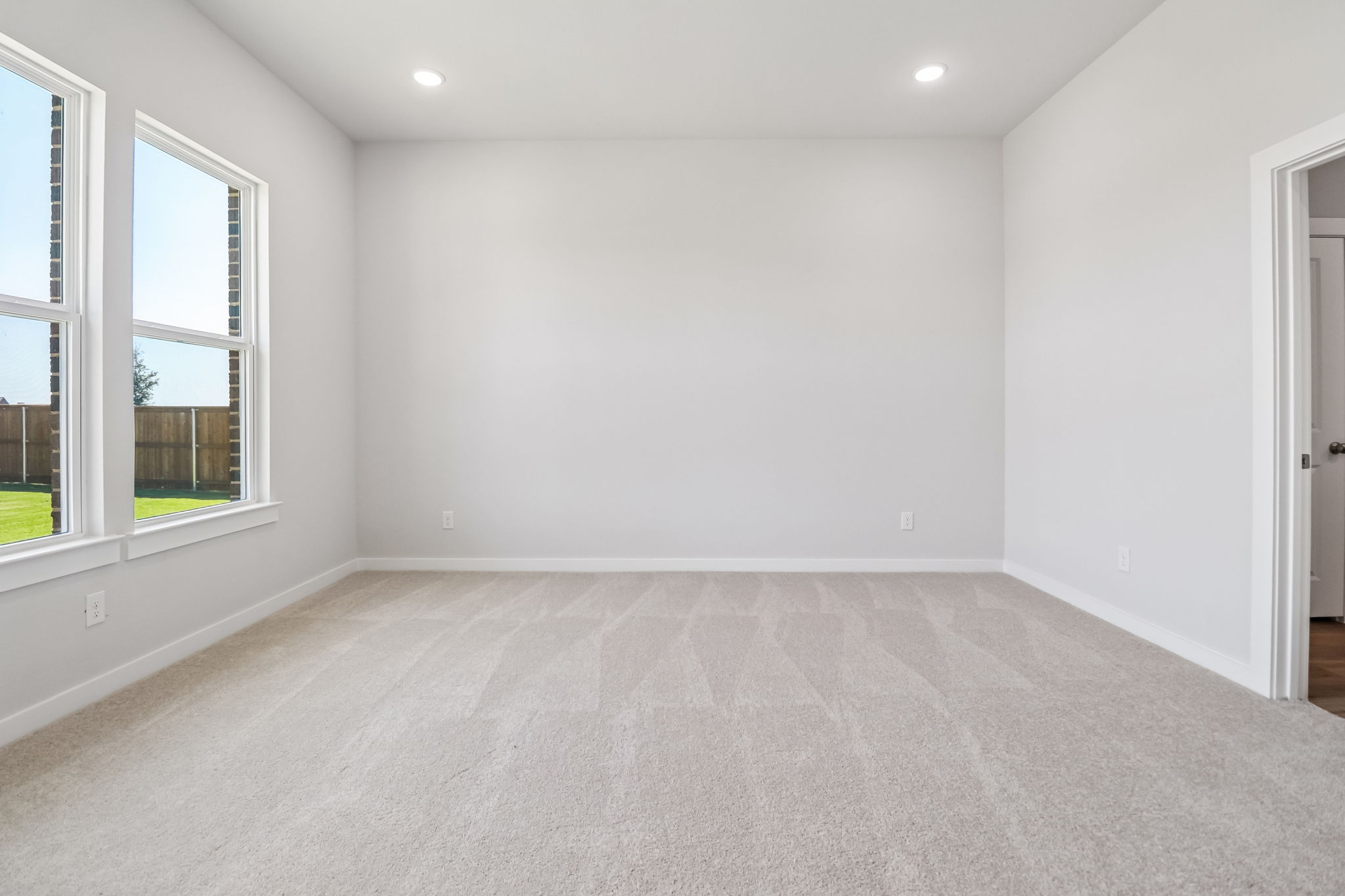 A room with a carpet and windows.