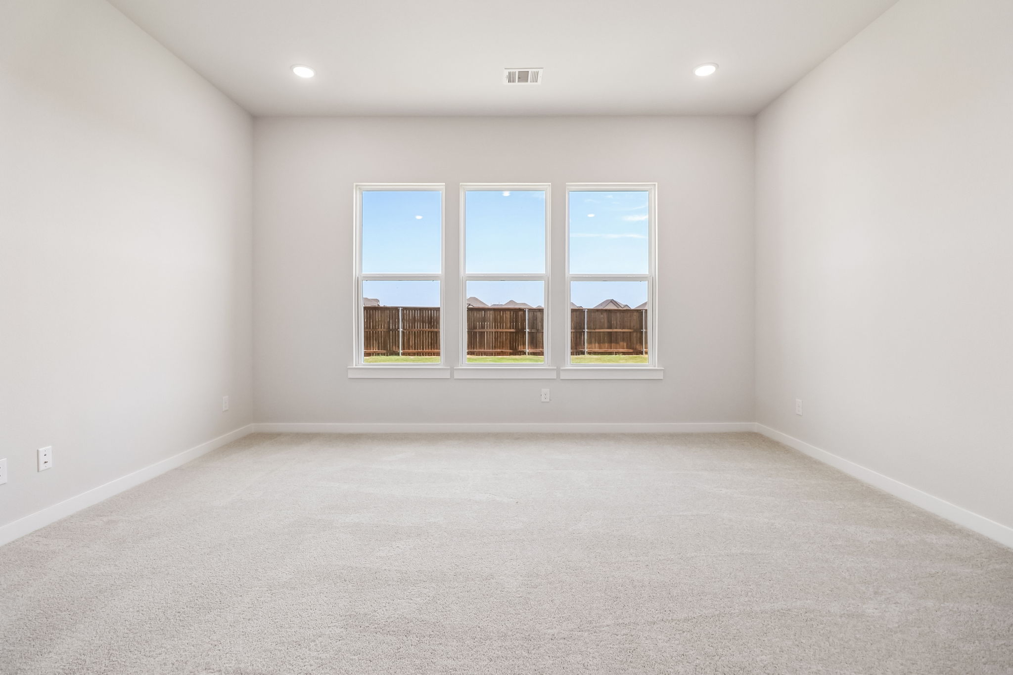 A room with a window and a carpet.