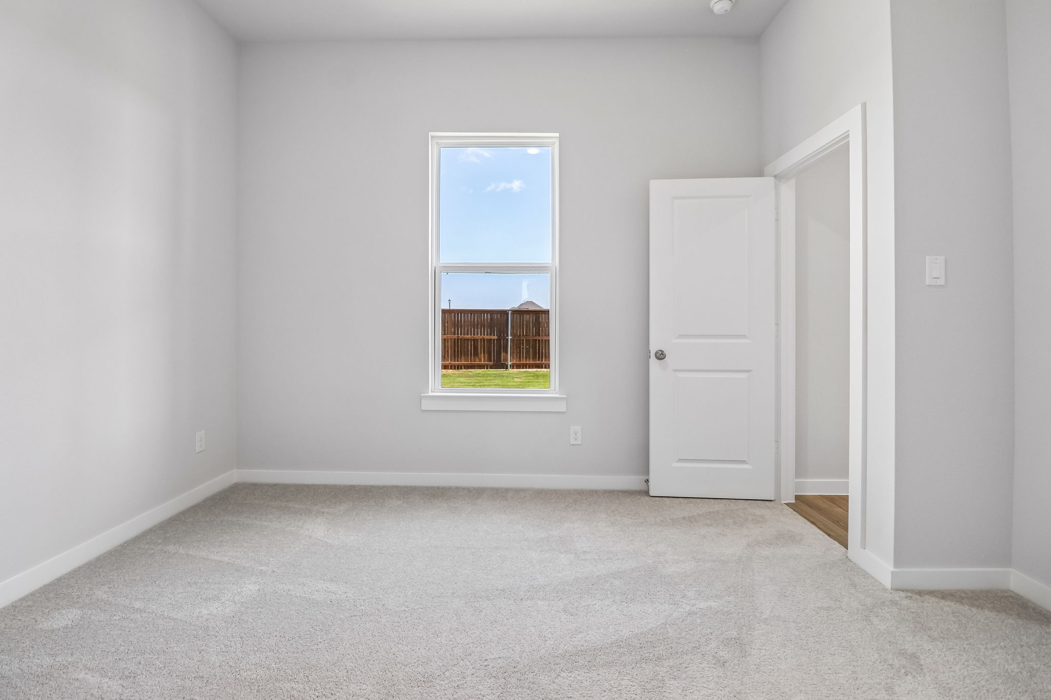 A room with white walls and a window.