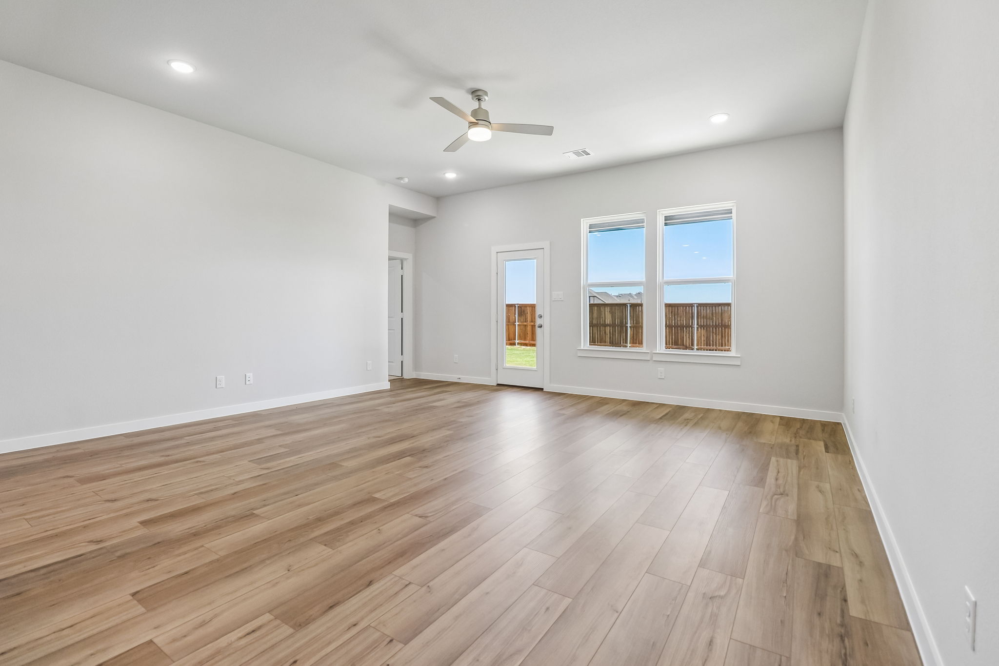A room with a wood floor and a ceiling fan.