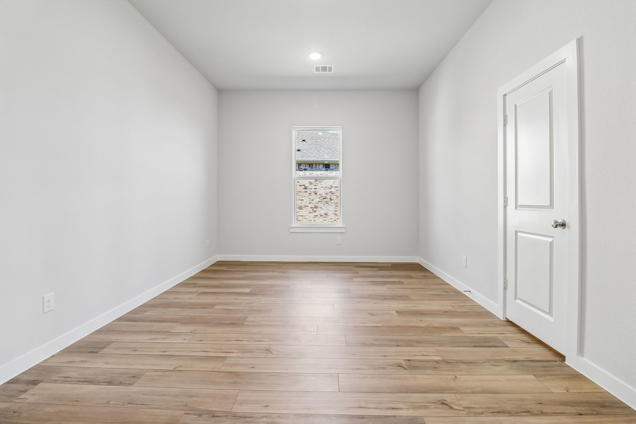 A room with white walls and a wood floor.