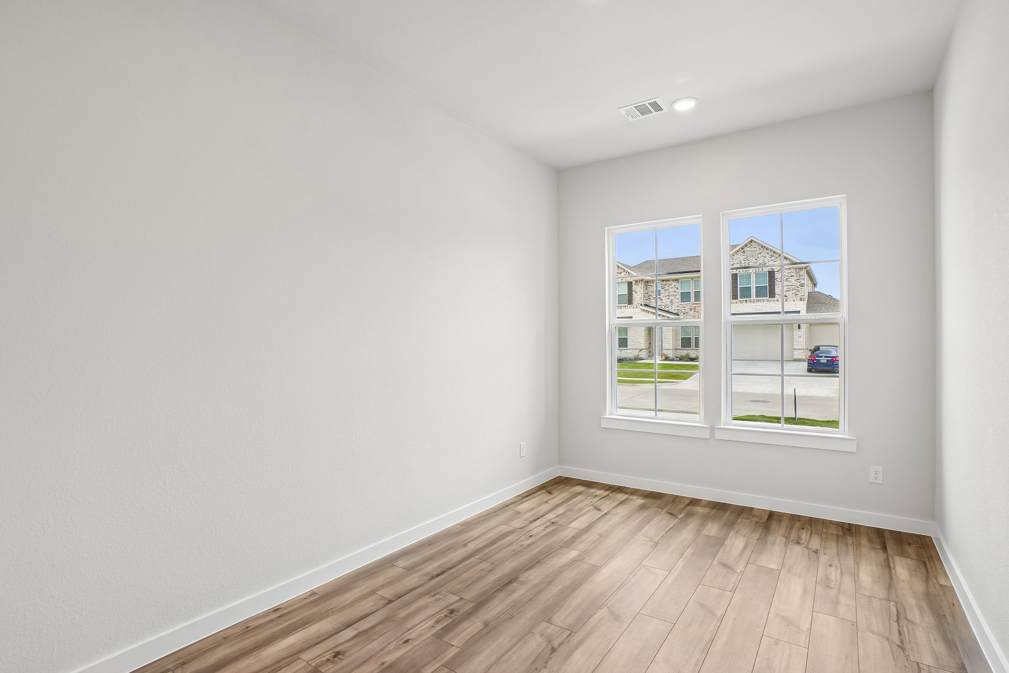 A room with a wood floor and a window with a wood floor.