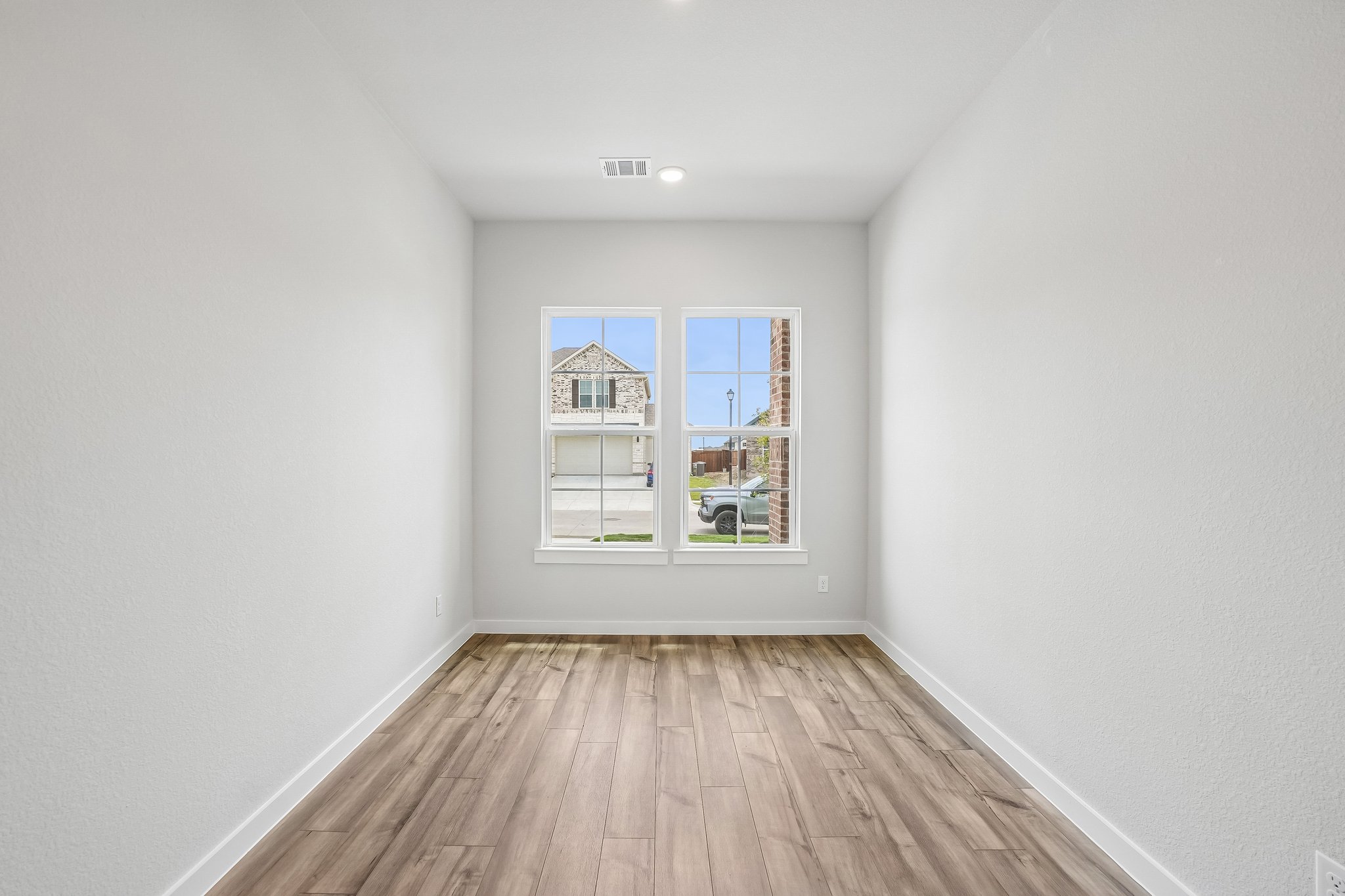 A room with a wood floor and a window with a wood floor.