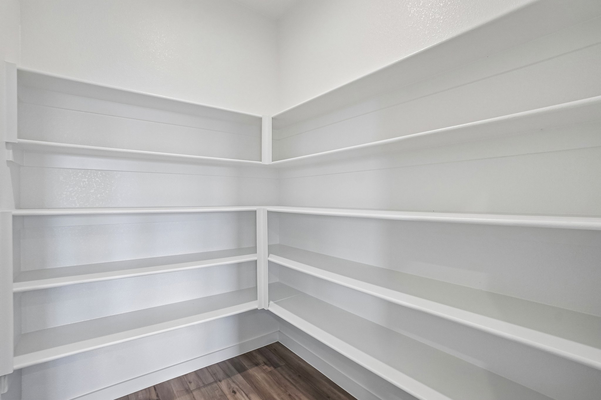 A white shelf with white walls.
