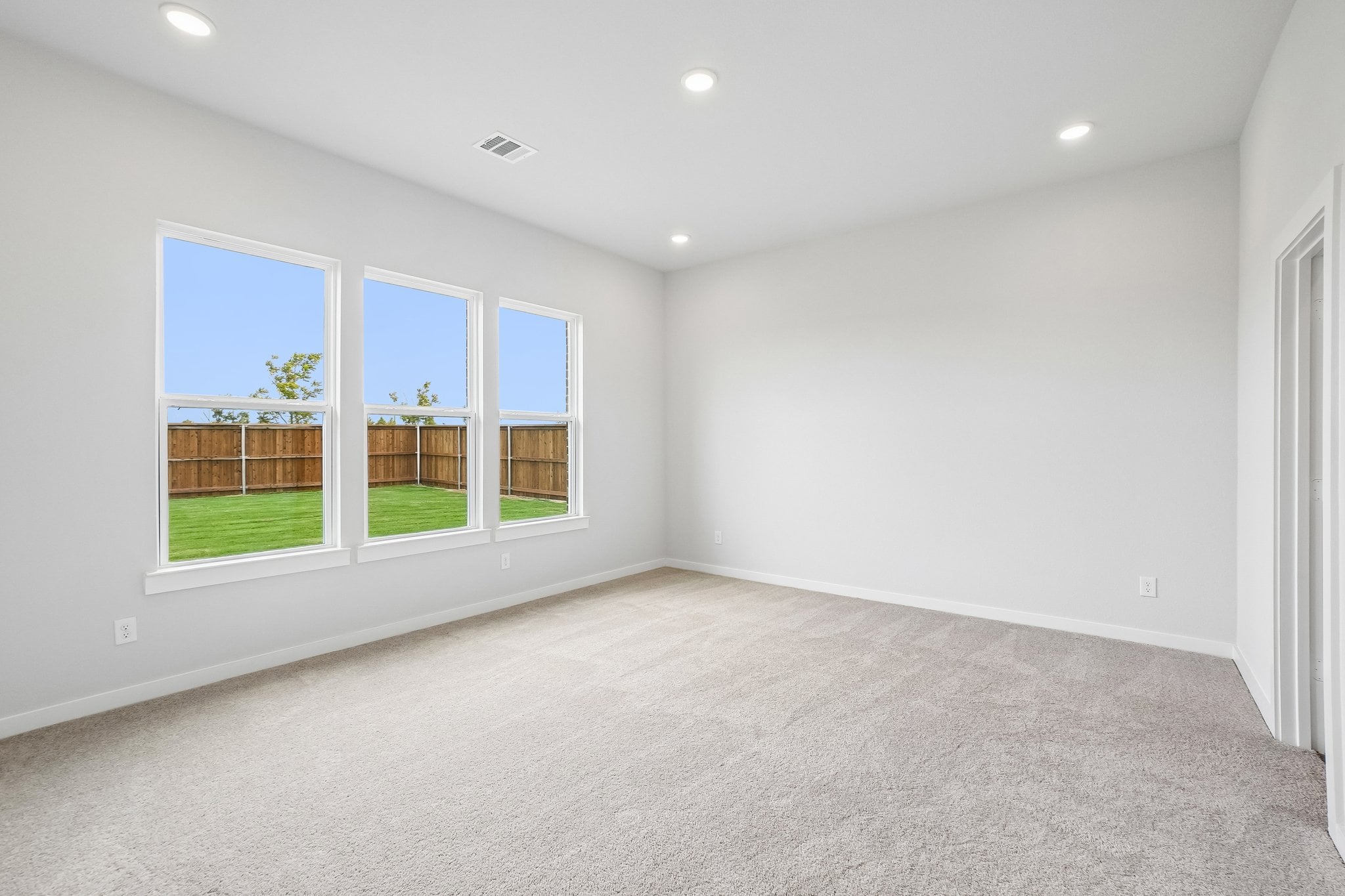 A room with a window and a carpet.