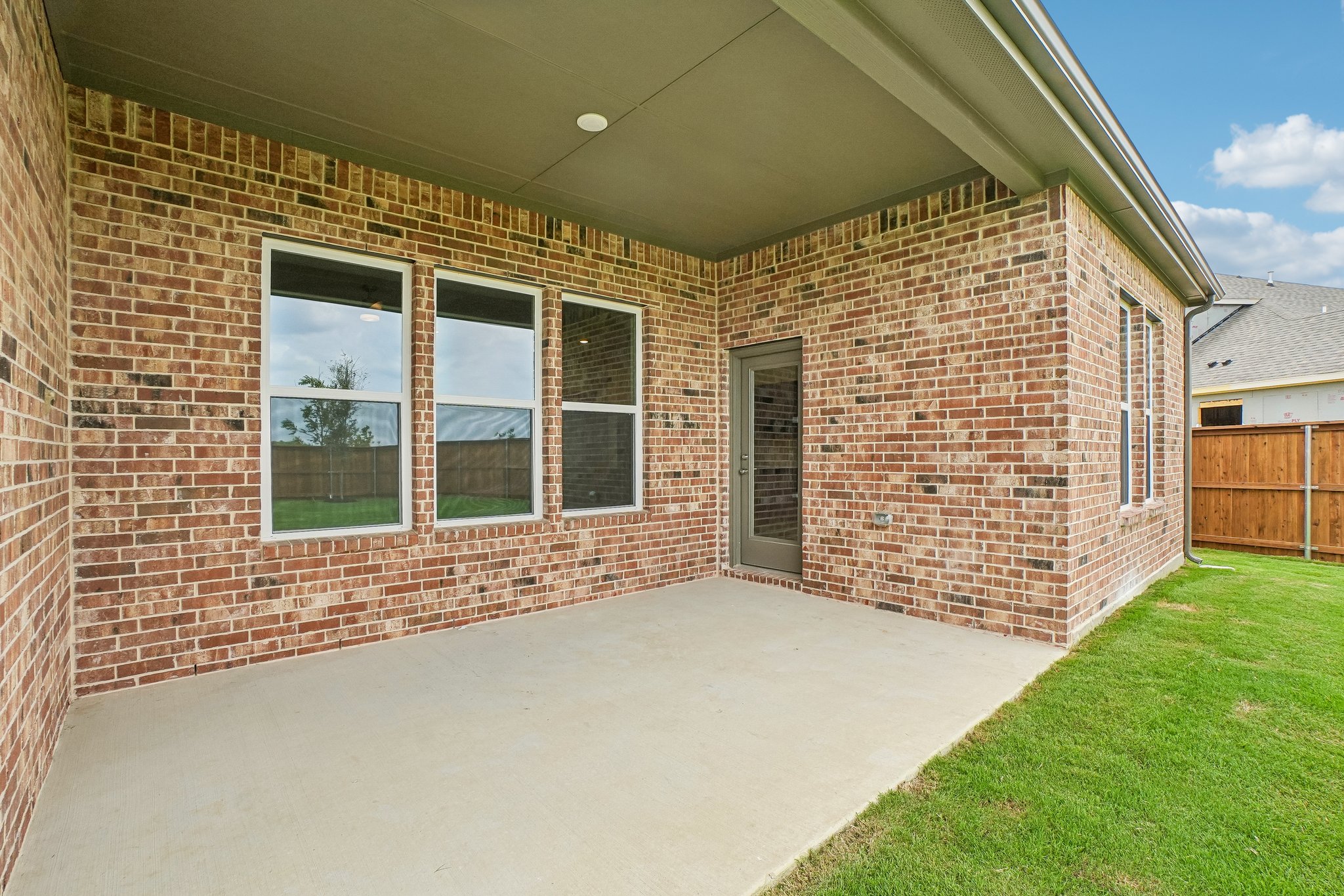 A brick building with a green lawn.