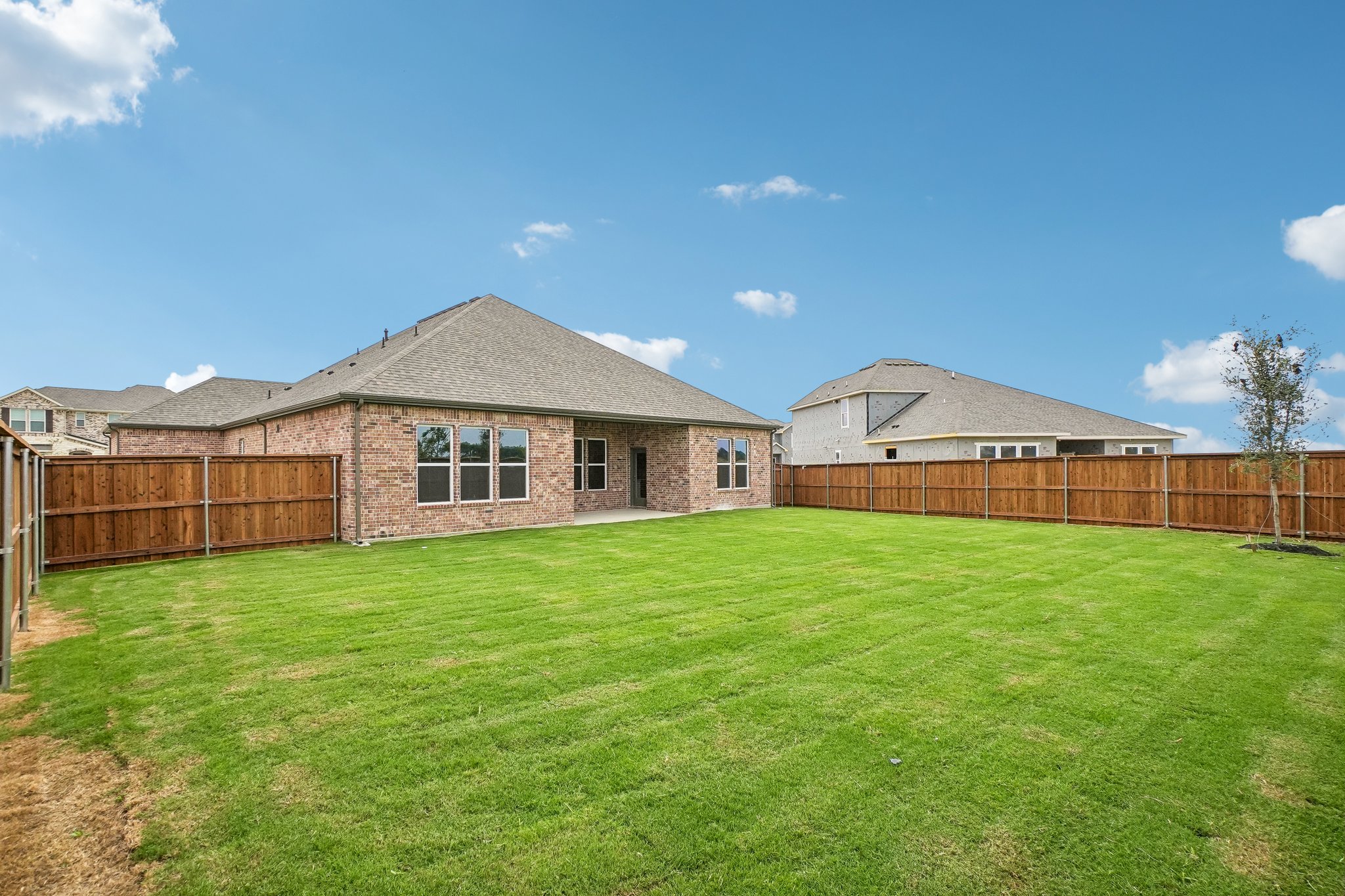 A large green lawn in front of a house.