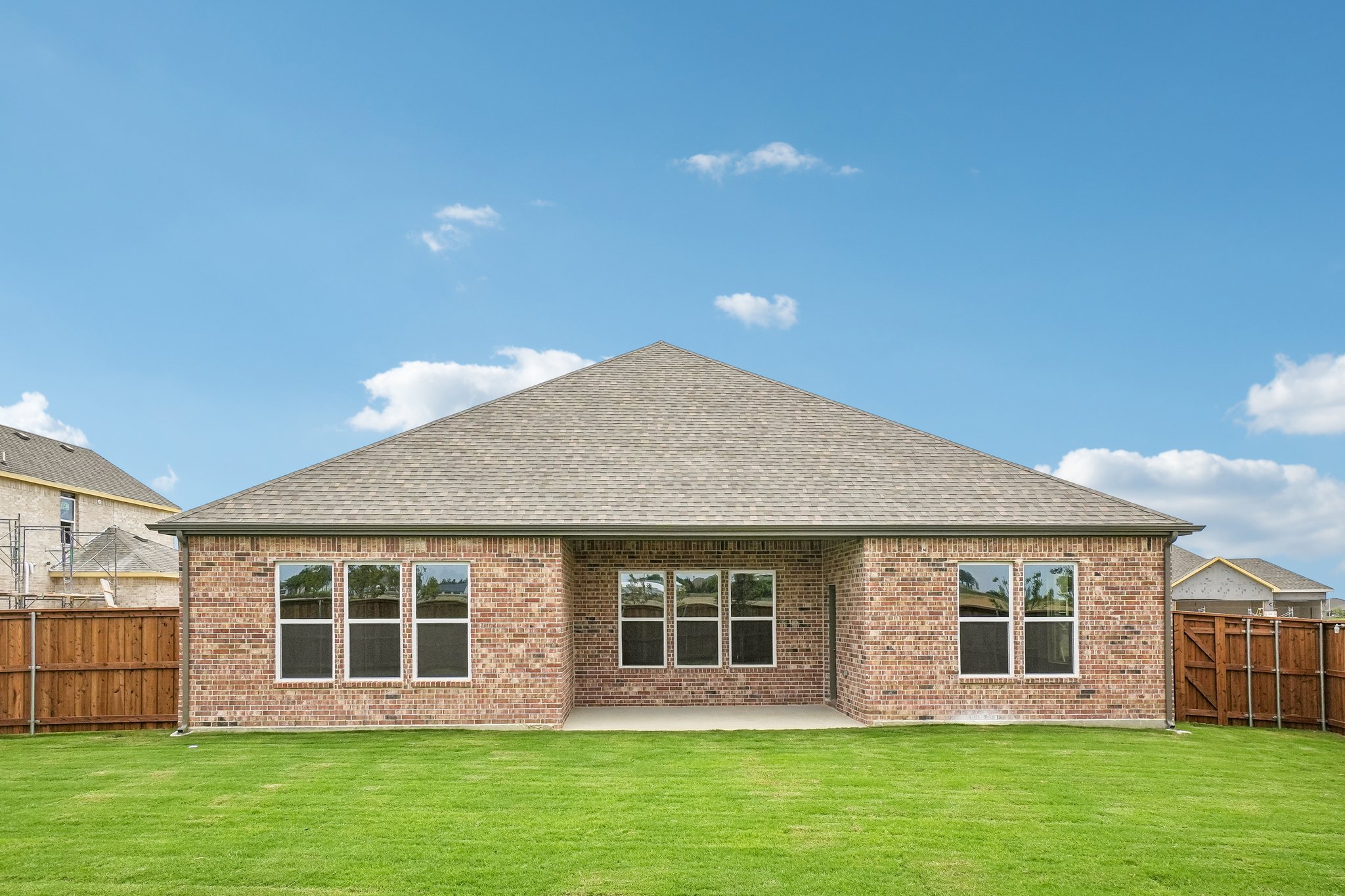 A brick house with a grass yard.