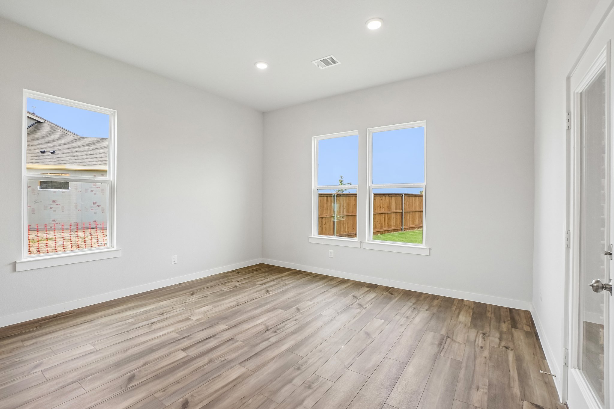 A room with a wood floor and windows.