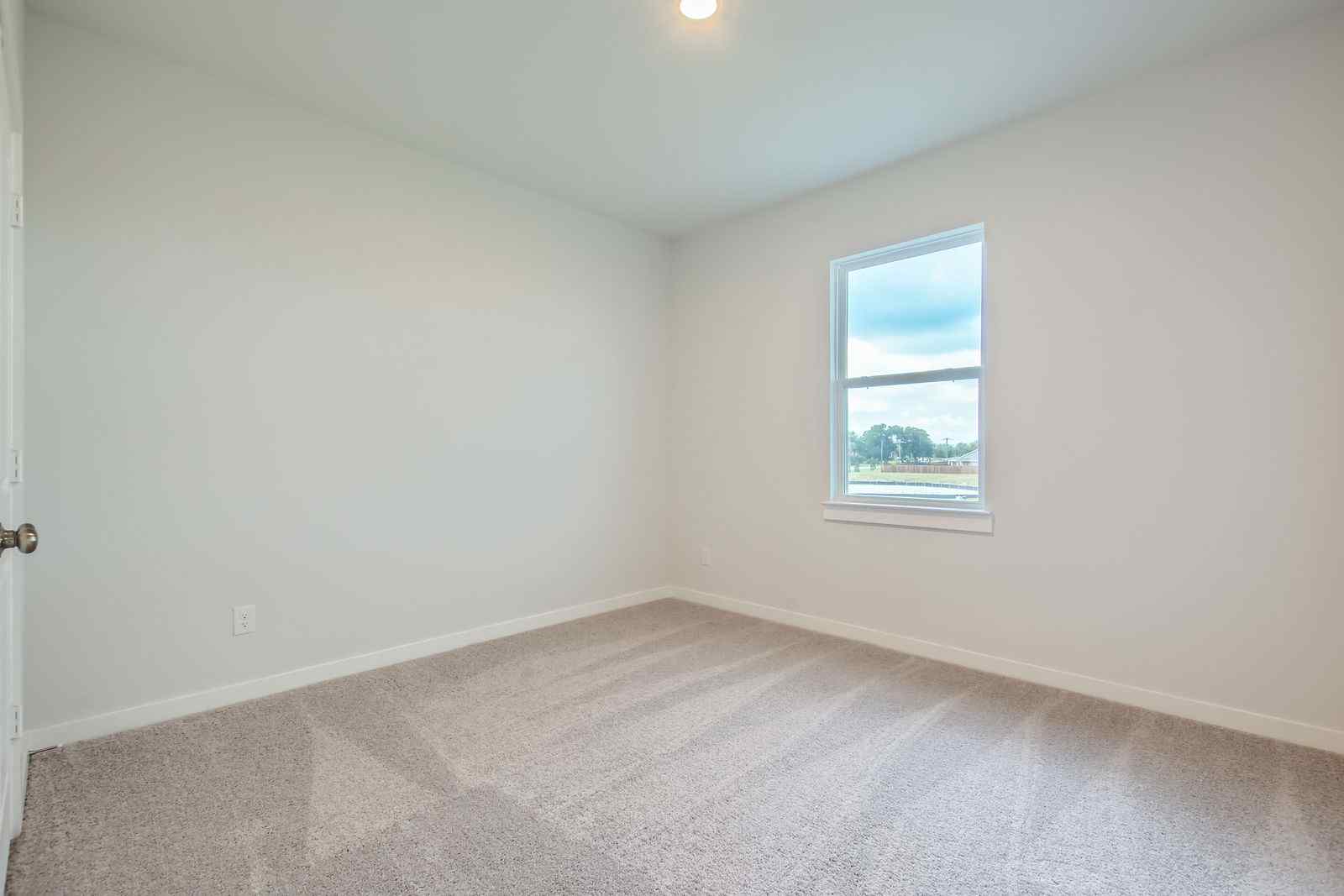 A room with a window and a carpet.