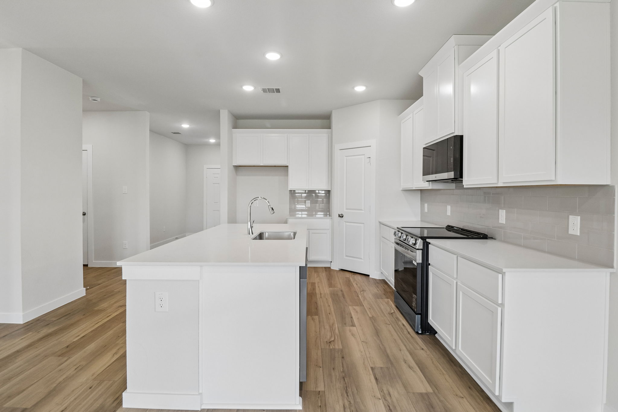 A kitchen with white cabinets.