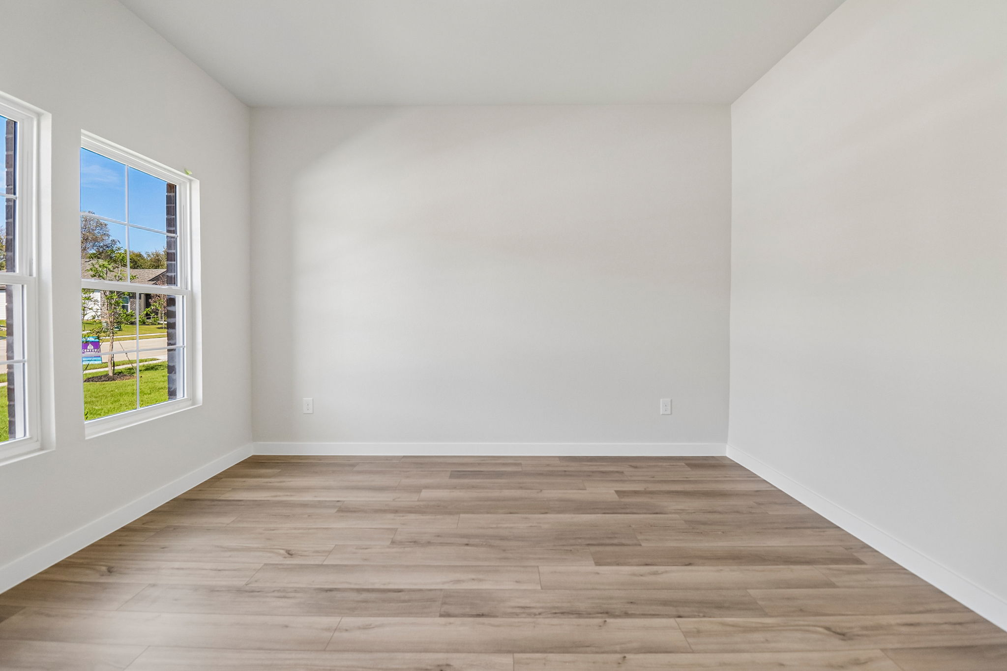A room with a wood floor and windows.