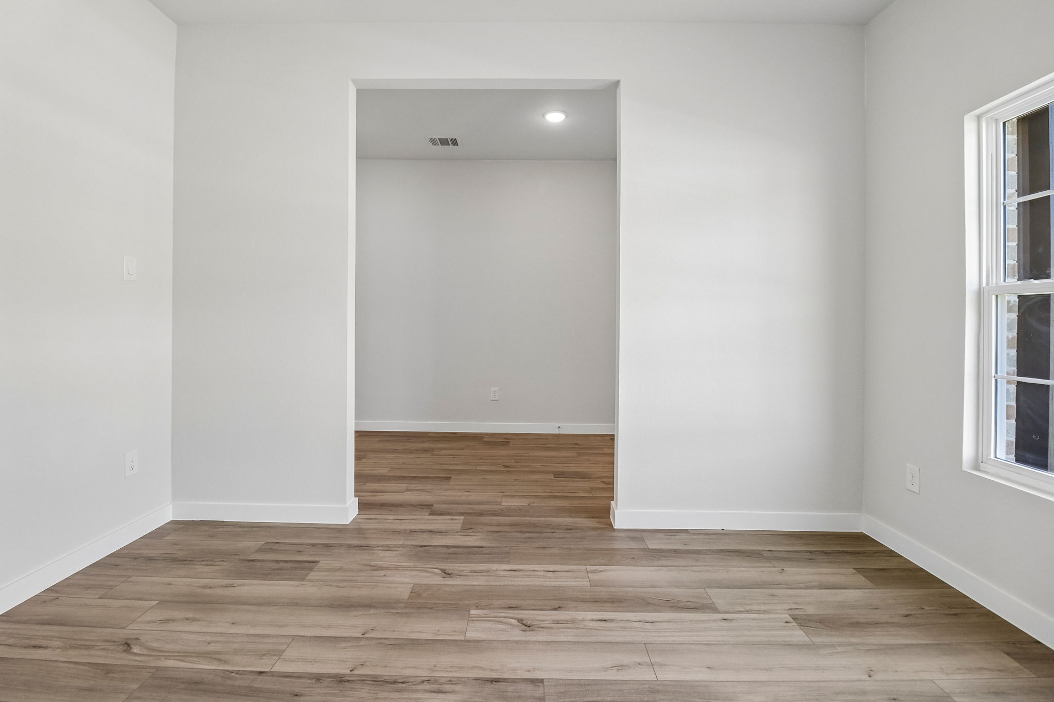 A room with a wood floor and a white door.