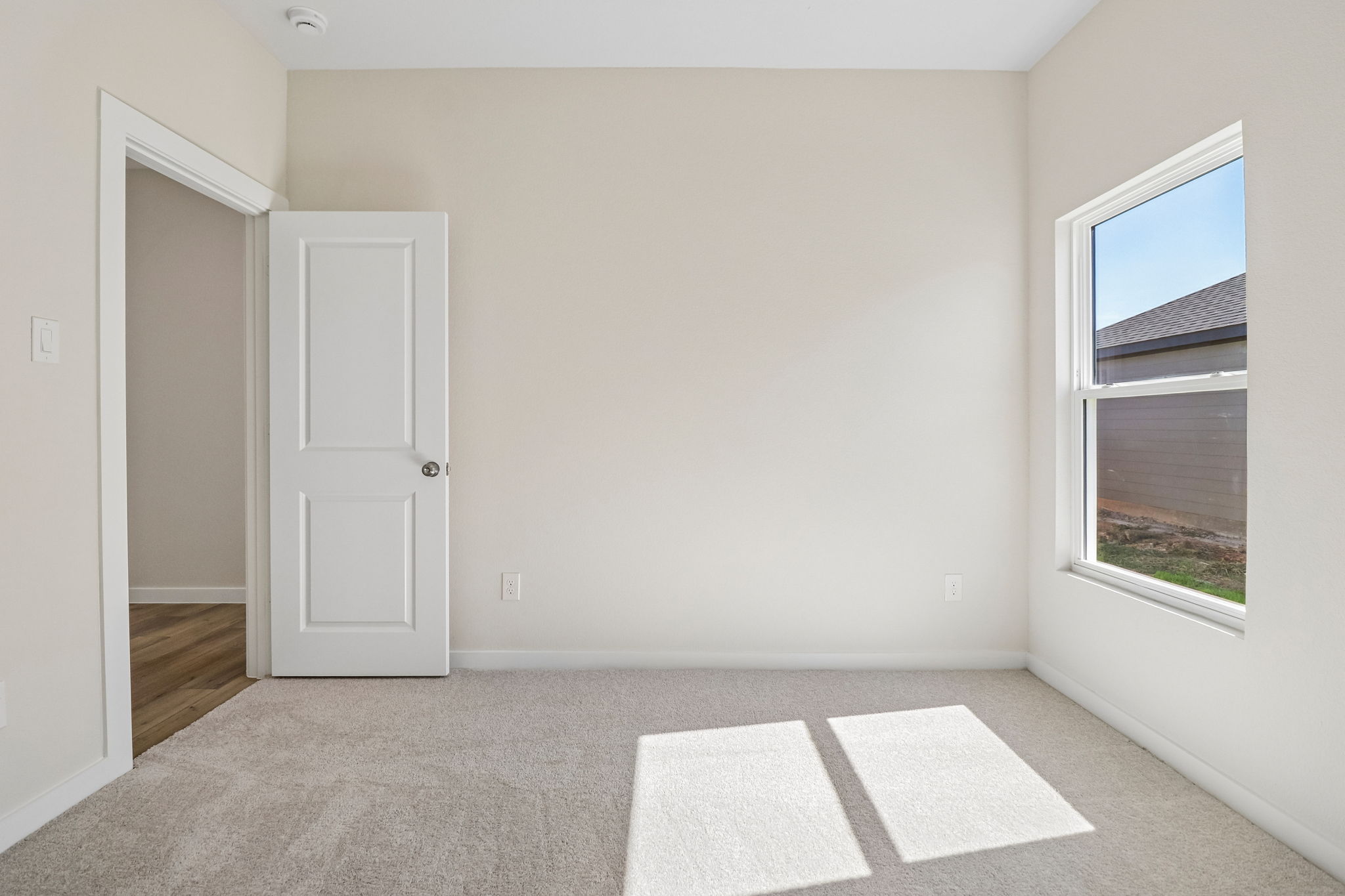 A room with a door and a rug.