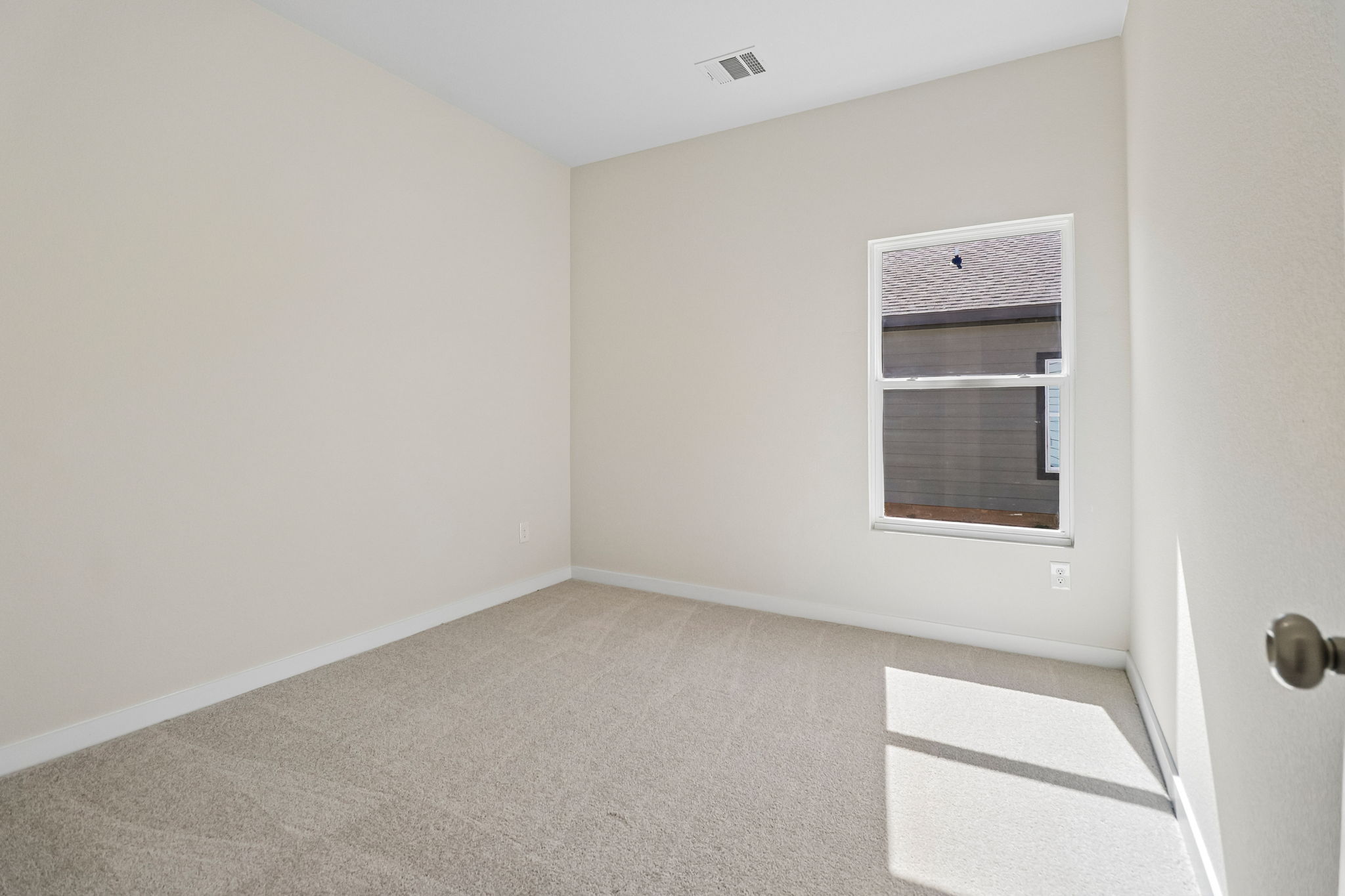A room with a window and carpet.