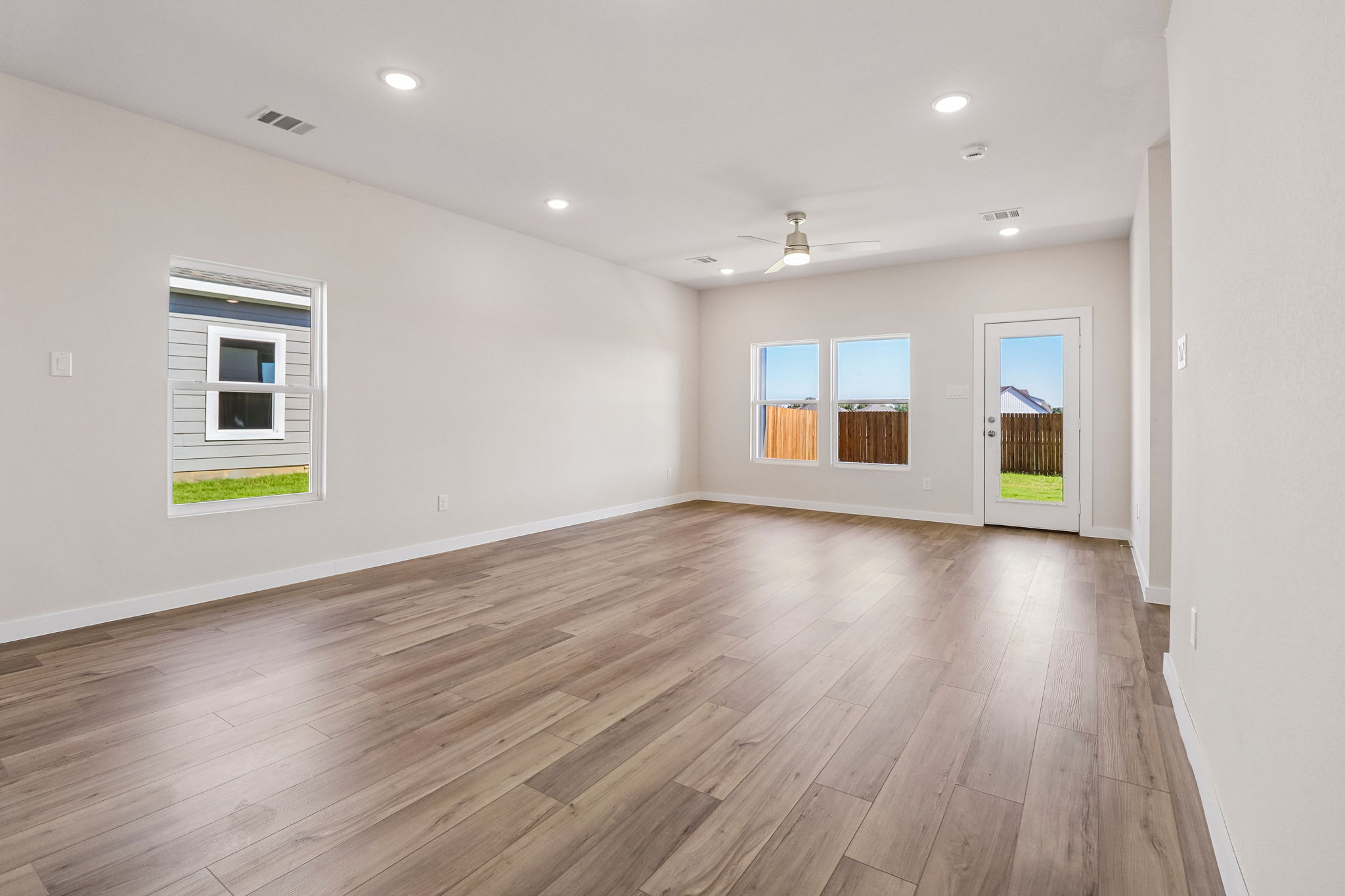 A room with a wood floor and windows.