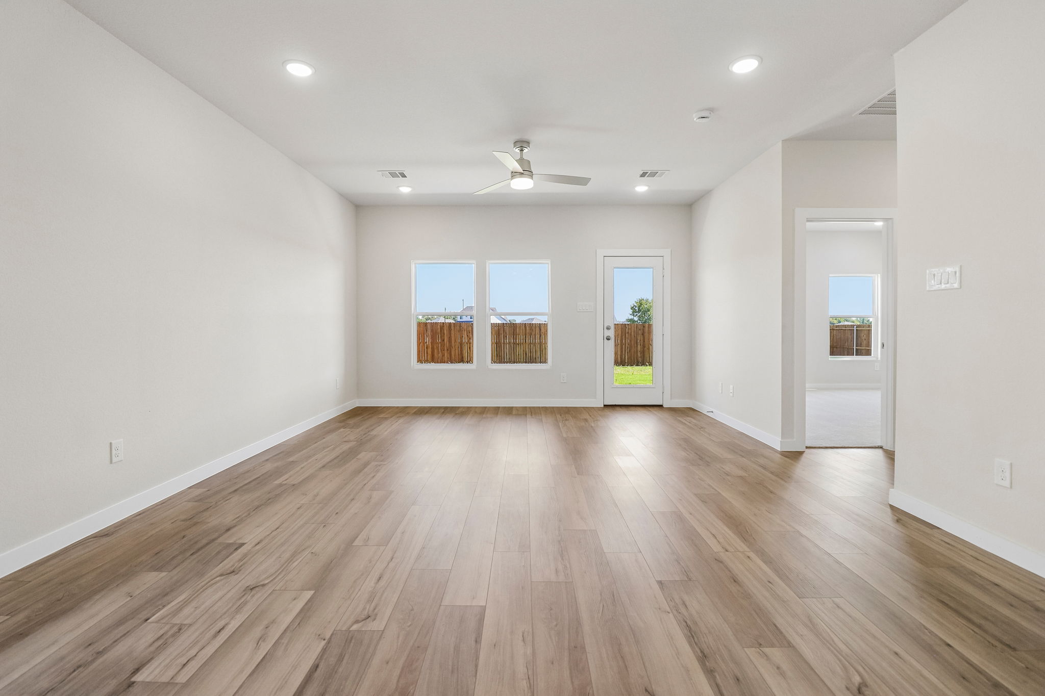 A large empty room with a wood floor and a wood floor.