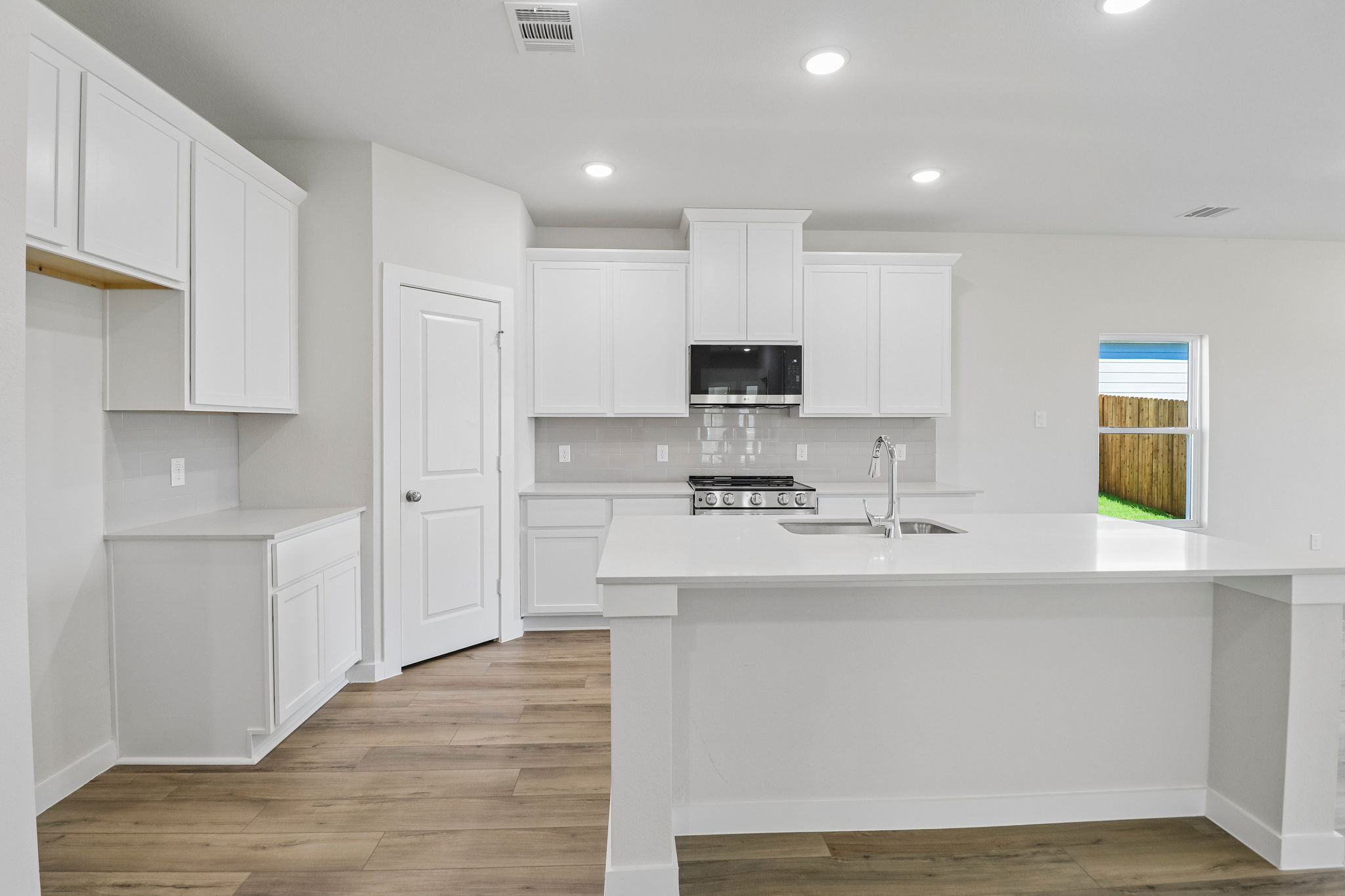A kitchen with white cabinets.