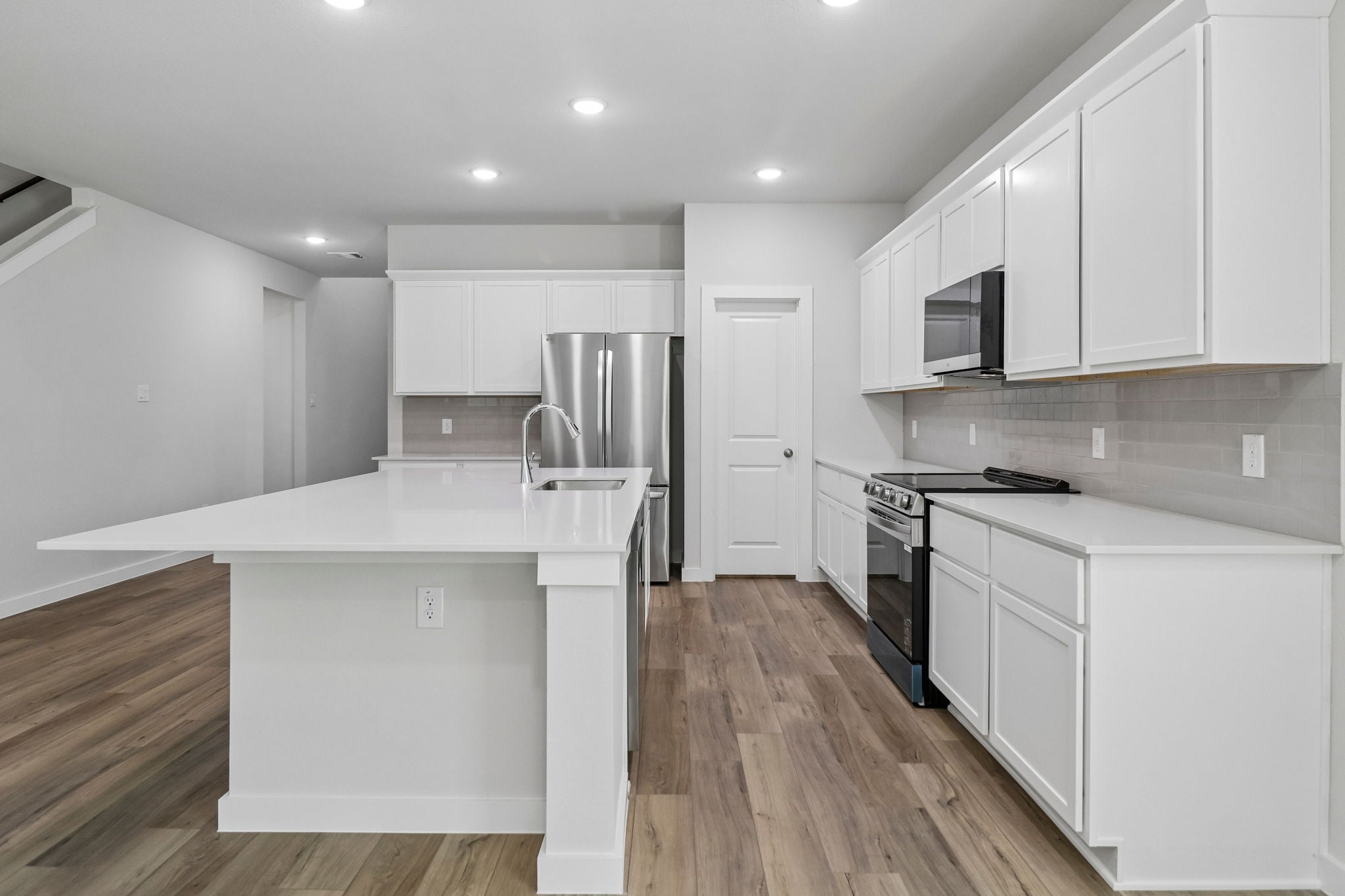 A kitchen with white cabinets.