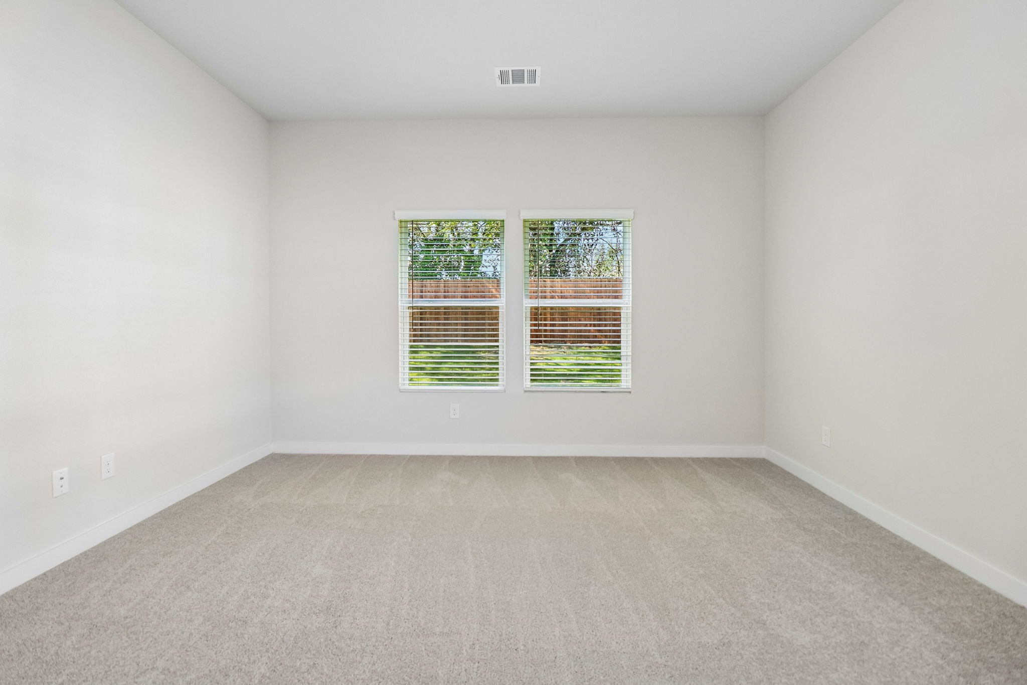 A room with a window and a carpet.
