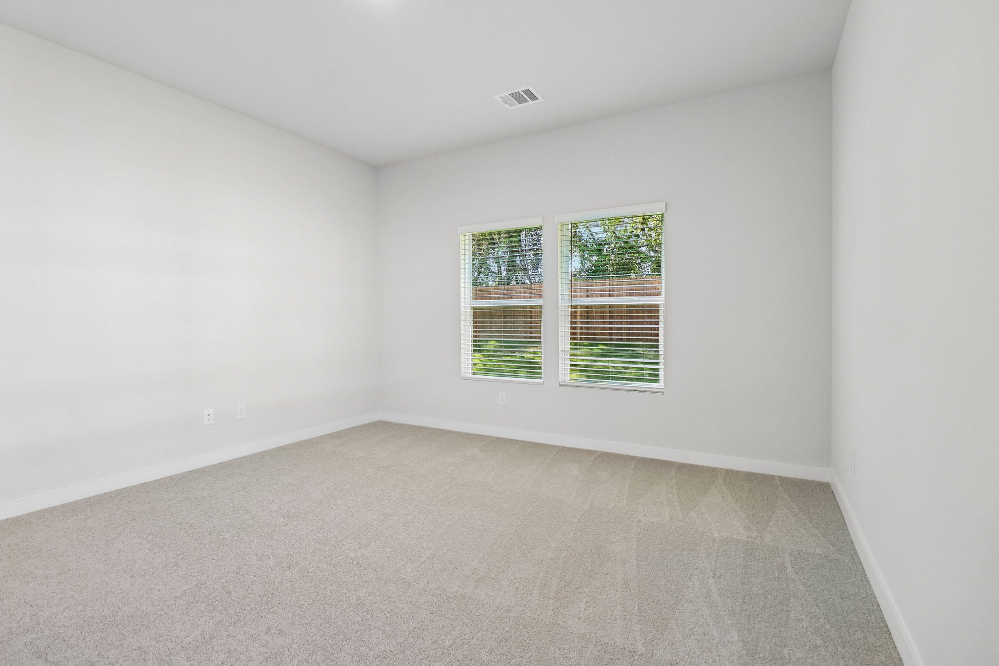A room with a window and a carpet.