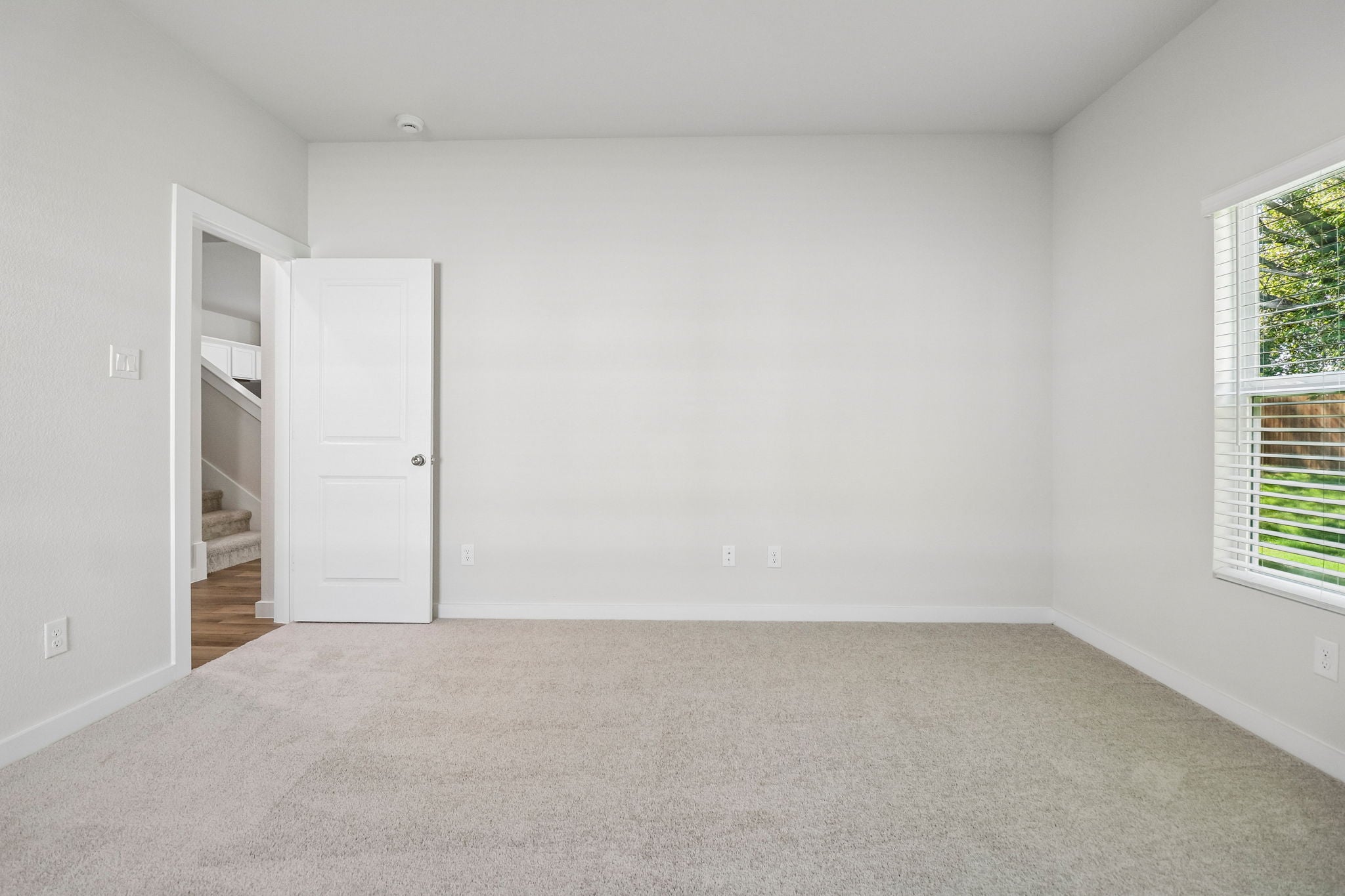A room with a white door and a white wall.