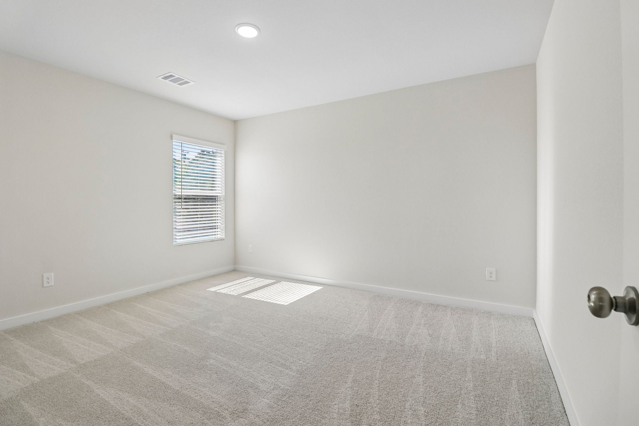 A room with a carpet and a window.