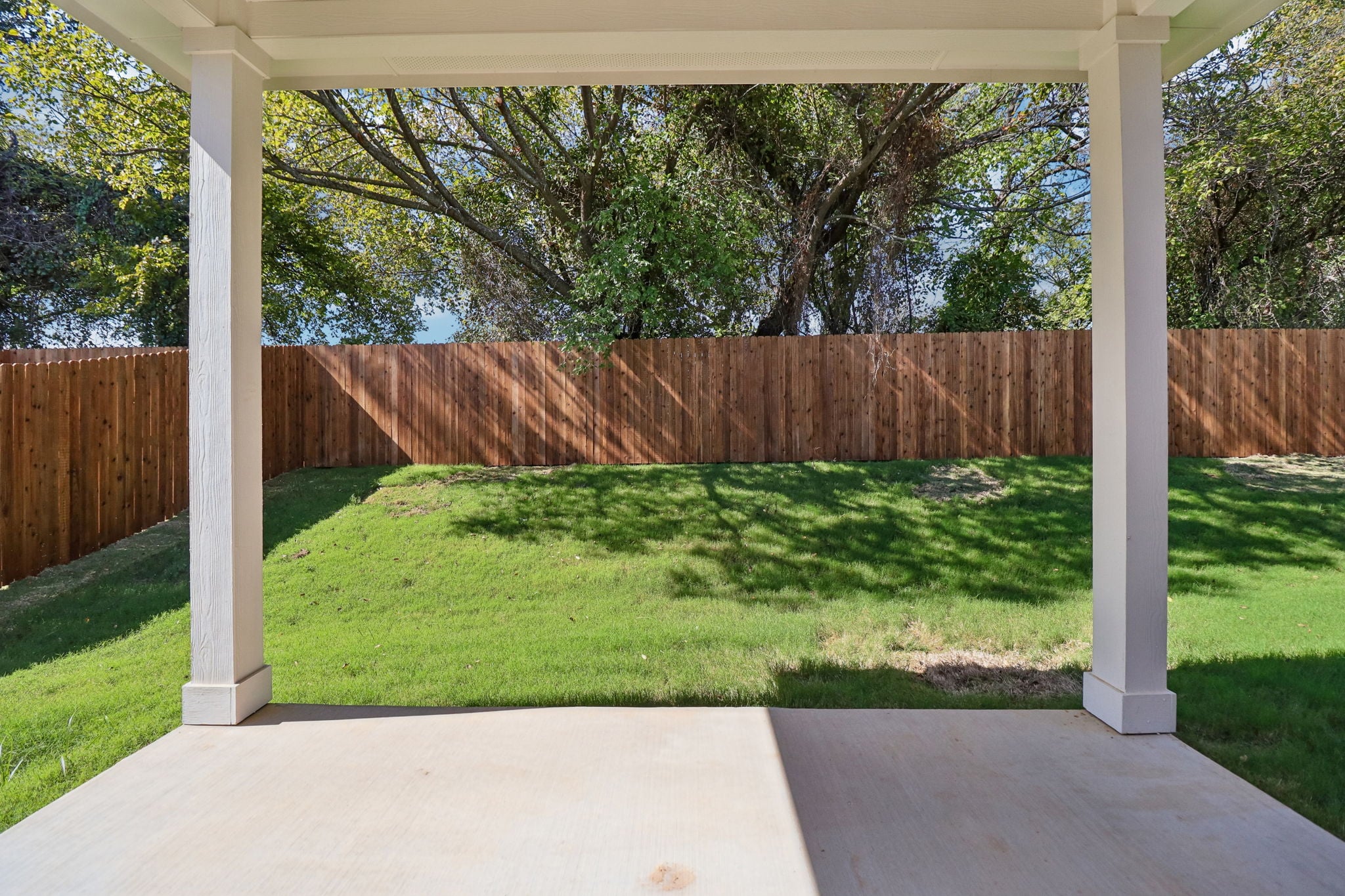 A fenced yard with a wood gate and a wood fence.