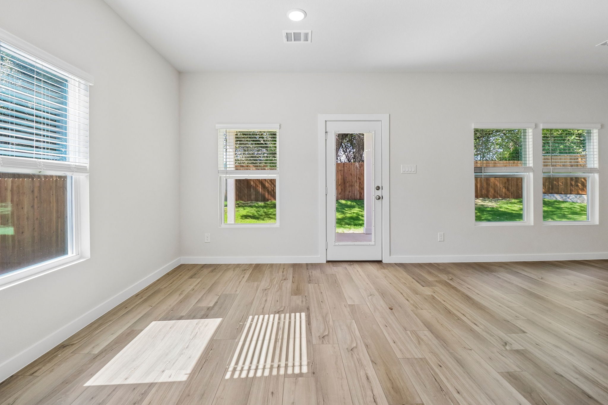 A room with windows and wood floors.