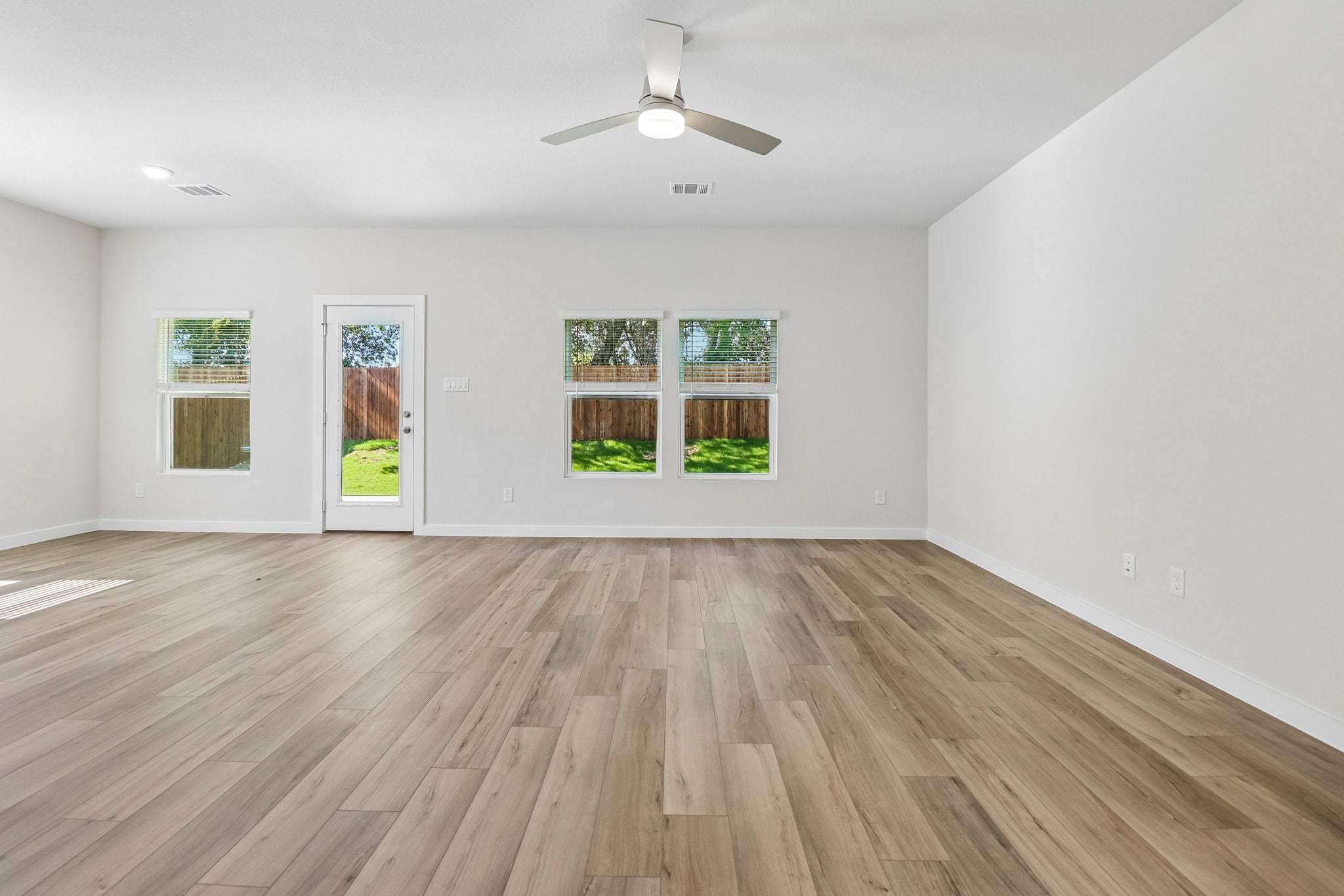 A room with a wood floor and a ceiling fan.