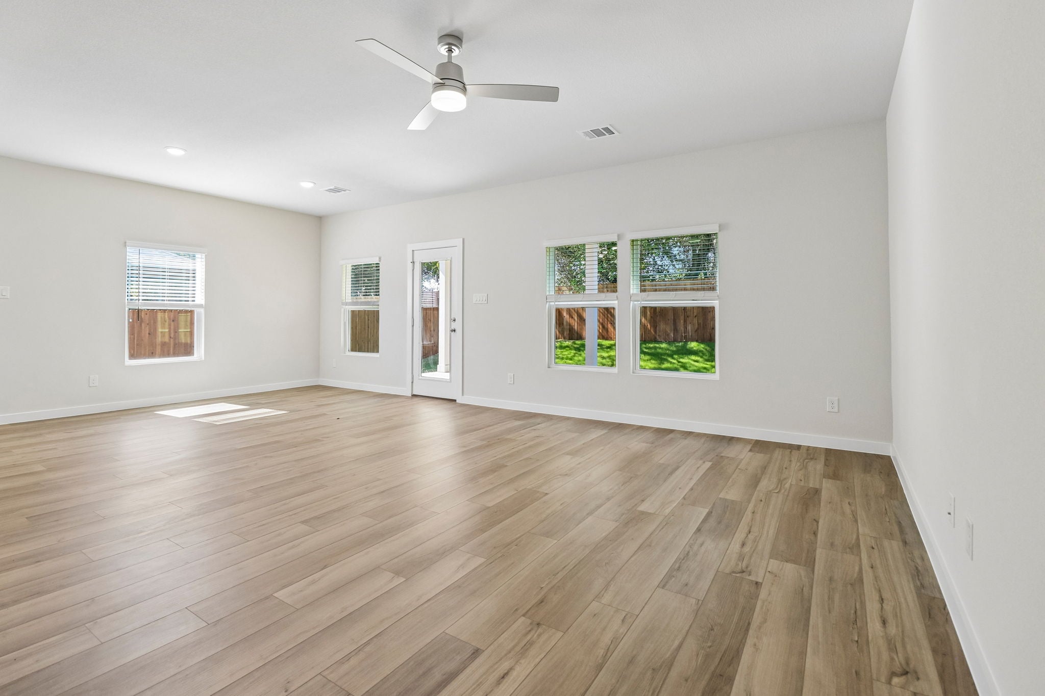 A room with a wood floor and a ceiling fan.