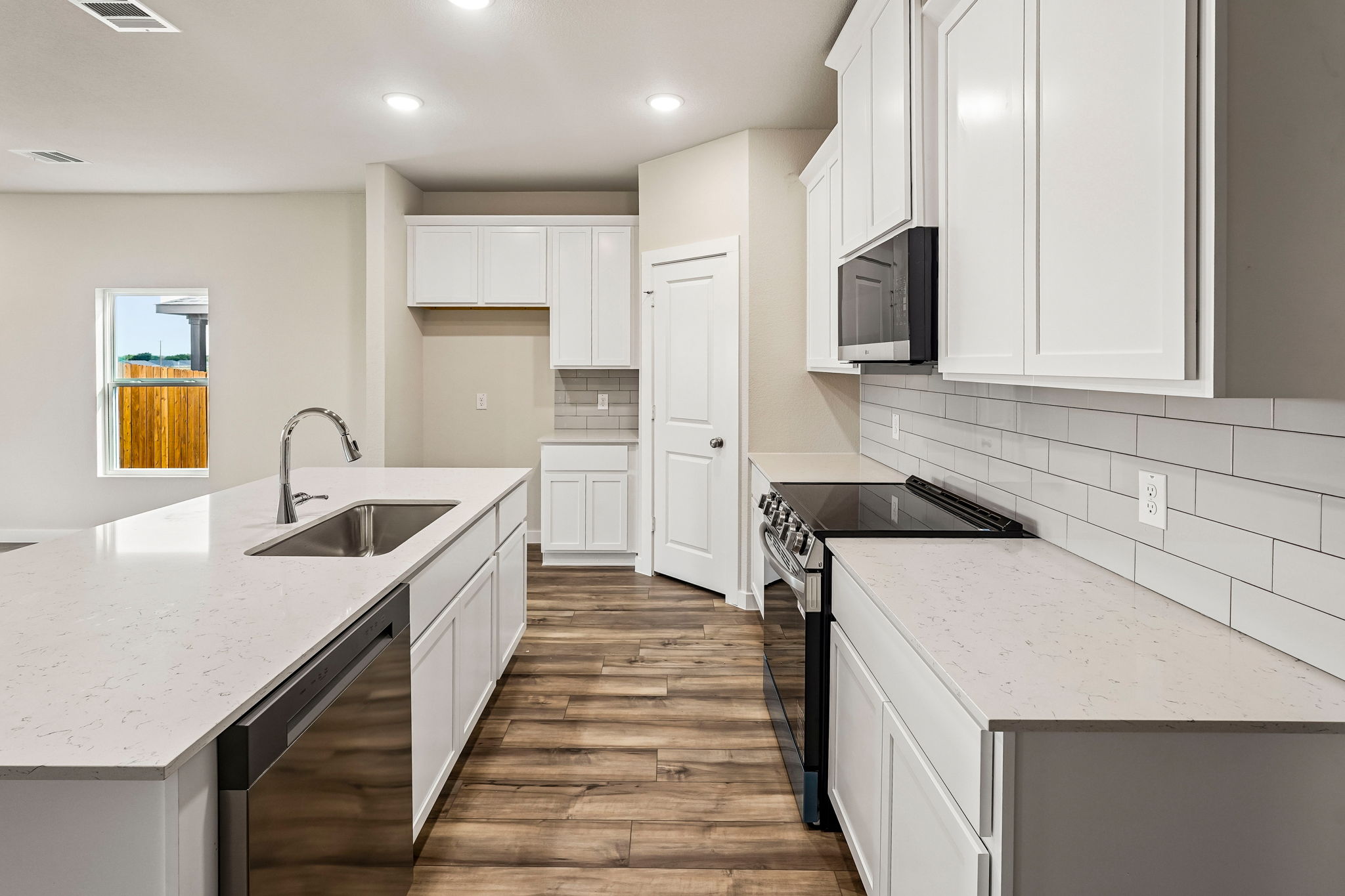 A kitchen with white cabinets.