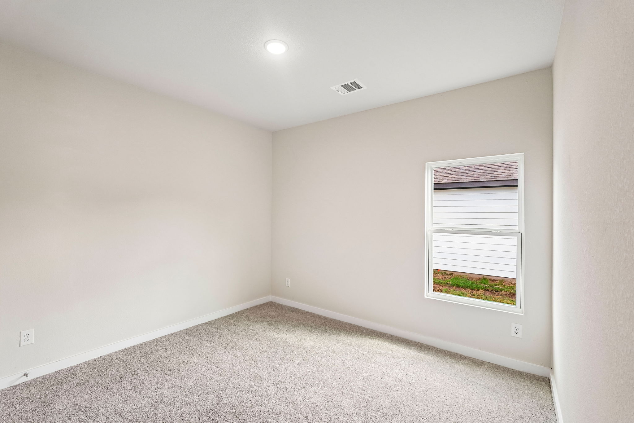 A room with a window and a carpet.