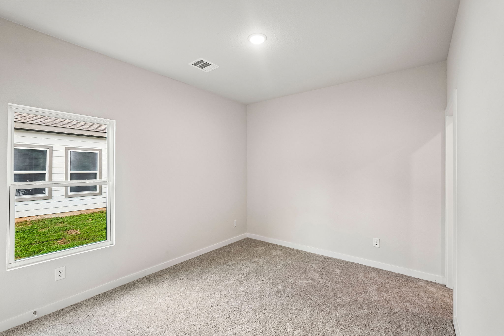 A room with a window and a carpet.