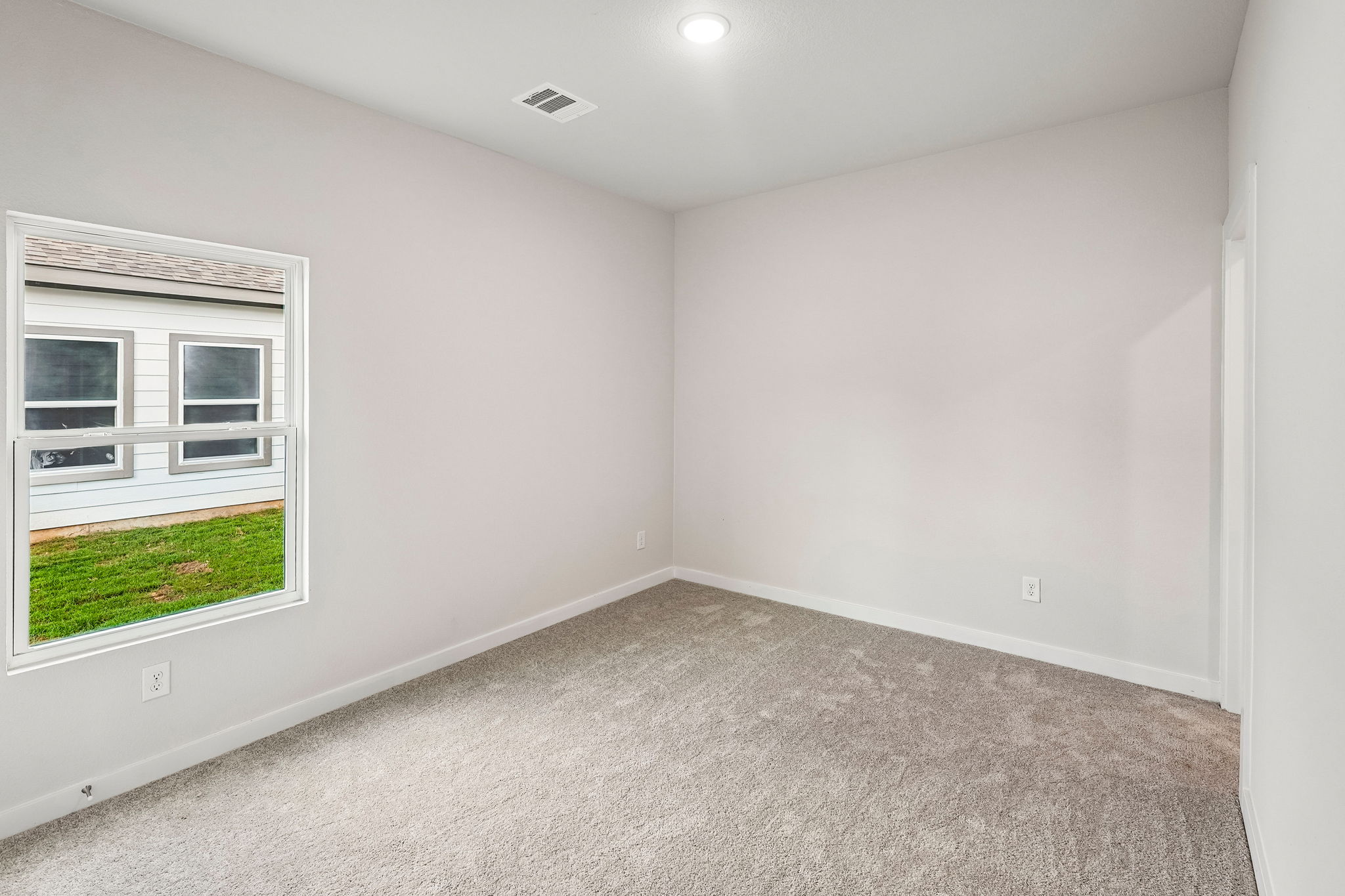 A room with a window and a carpet.