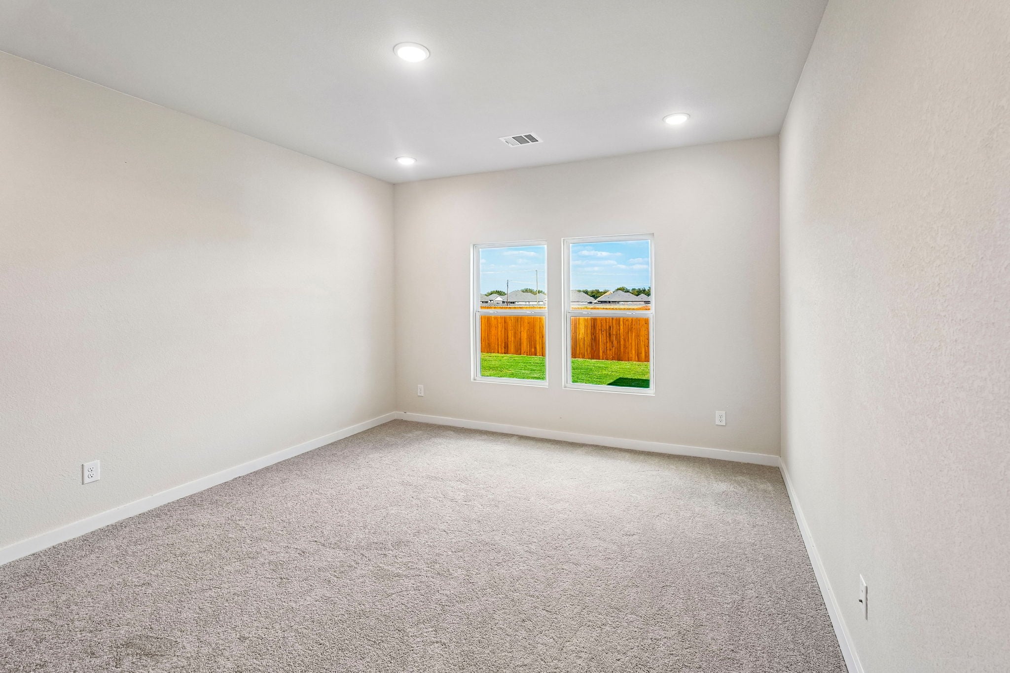 A room with a window and carpet.
